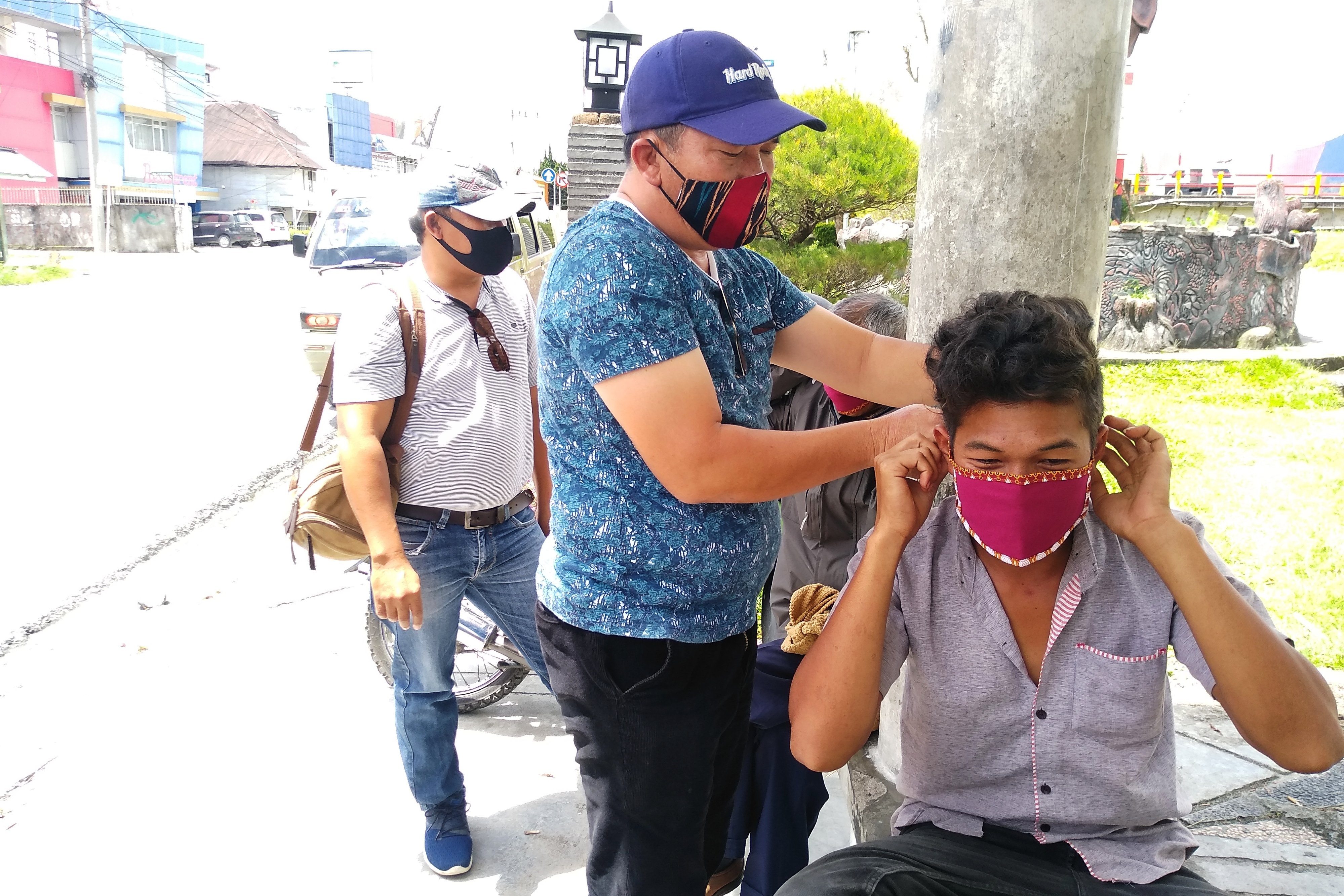 Ketua PWI Posma Simorangkir (kanan) bersama Sekretaris PWI Bona Pasogit (kiri) Alfonso Situmorang membagikan masker kepada warga.