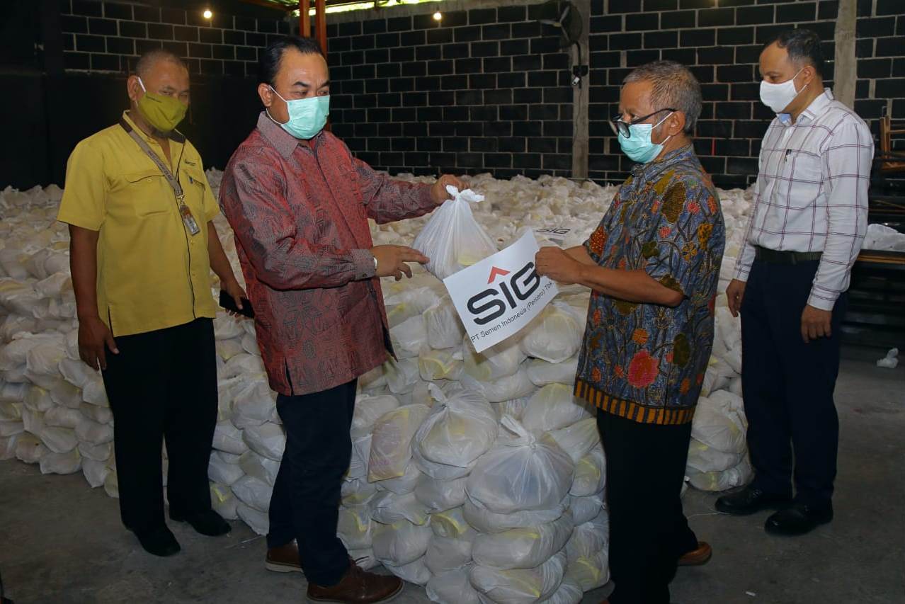 Kepala Departemen CSR SIG Edy Saraya (kedua dari kiri) menyerahkan paket bantuan di Gresik, Jawa Timur.