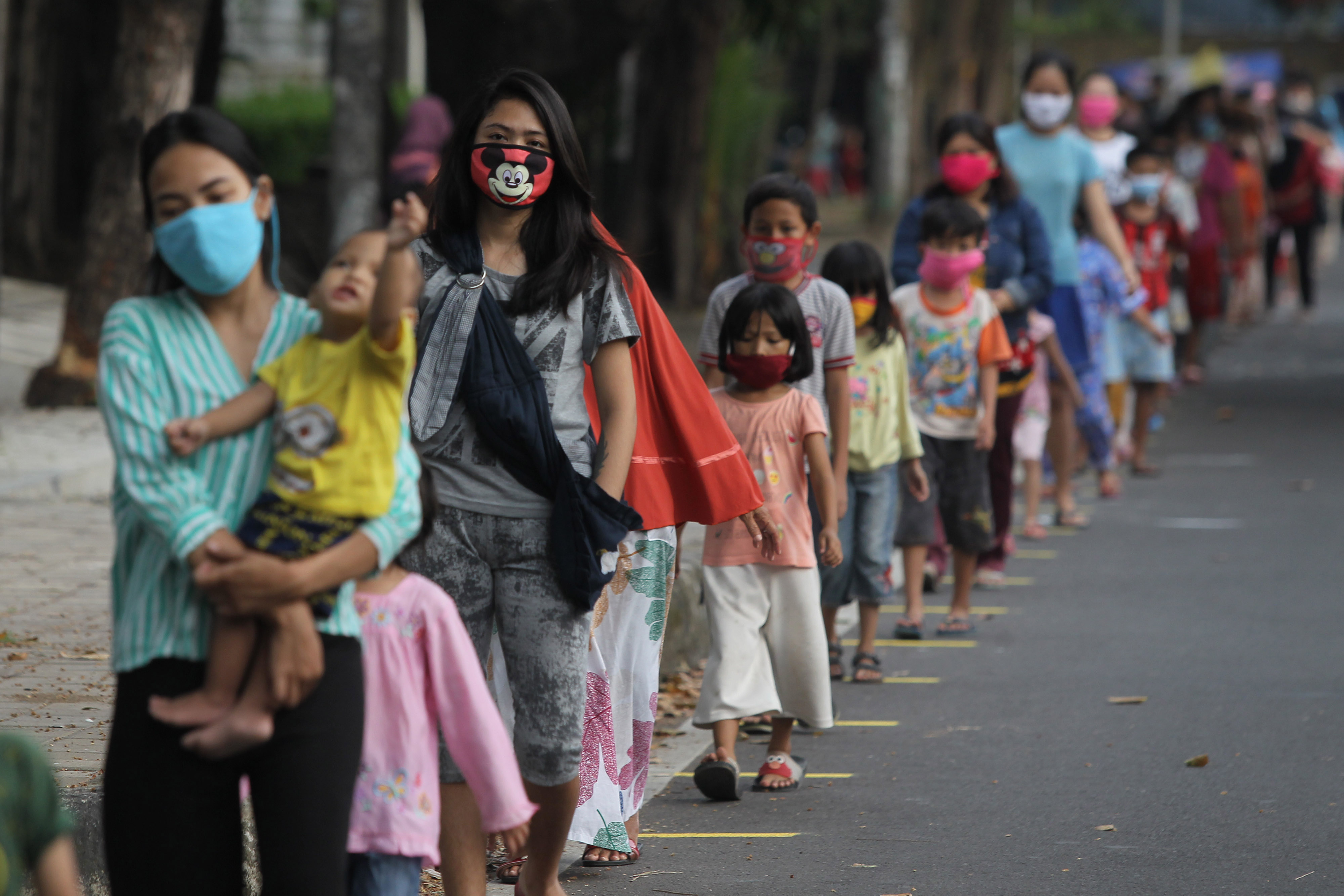 Warga mengantre pembagian takjil gratis dengan menerapkan pembatasan jarak fisik di Jalan Cempaka Putih Tengah, Jakarta, Sabtu (9/5/2020)