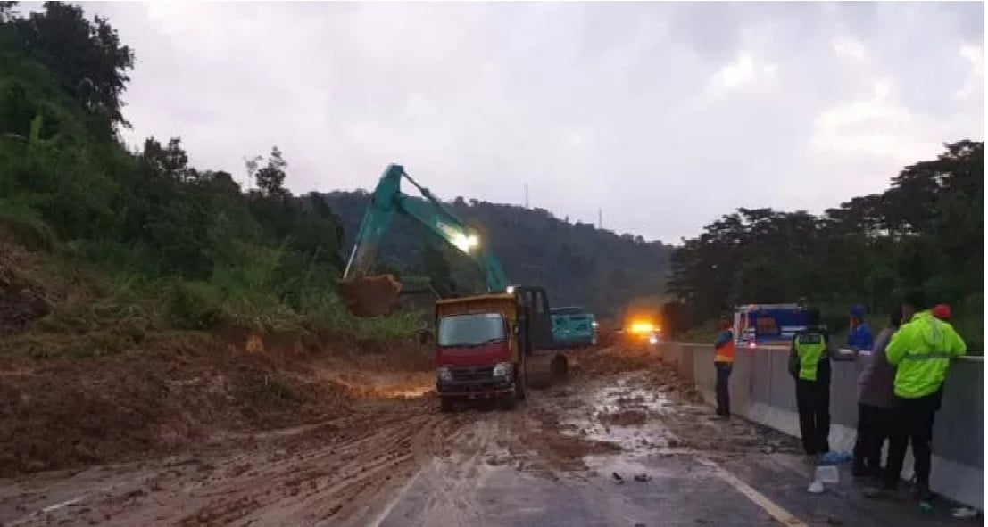 Petugas membersihkan jalan di ruas KM 426 Tol Semarang-Solo yang tertimbun longsor, Minggu