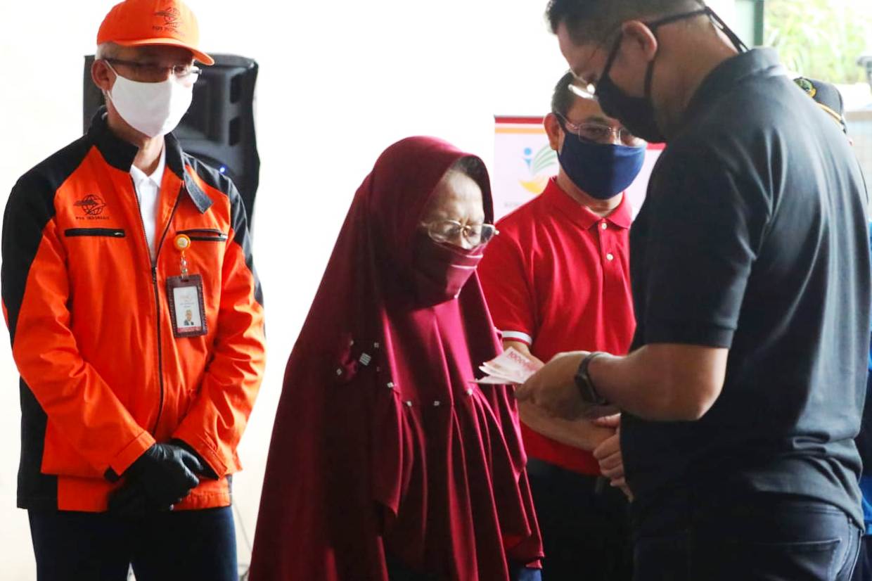 Mensos Juliari Batubara (kanan) menyerahkan BST.