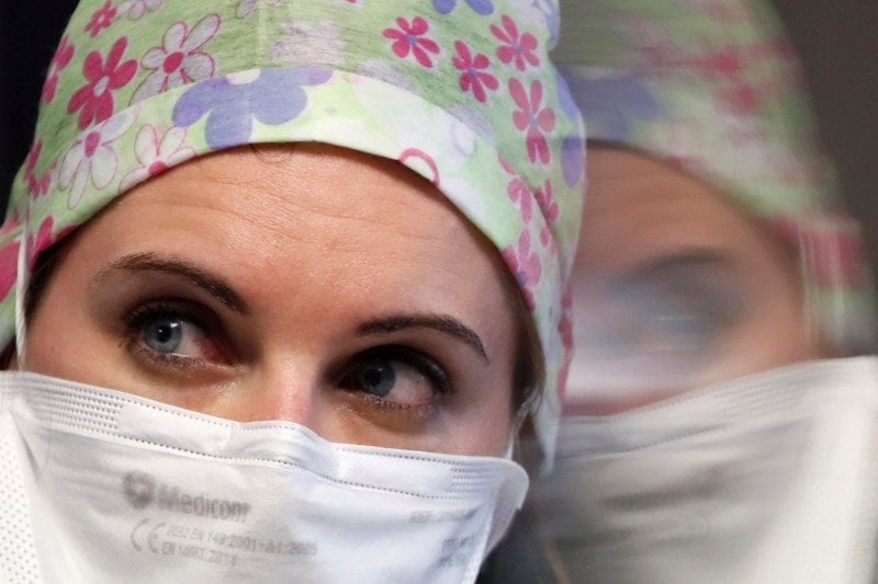 Seorang perawat memakai masker saat beristirahat di unit perawatan intensif bagi pasien terinfeksi virus korona.