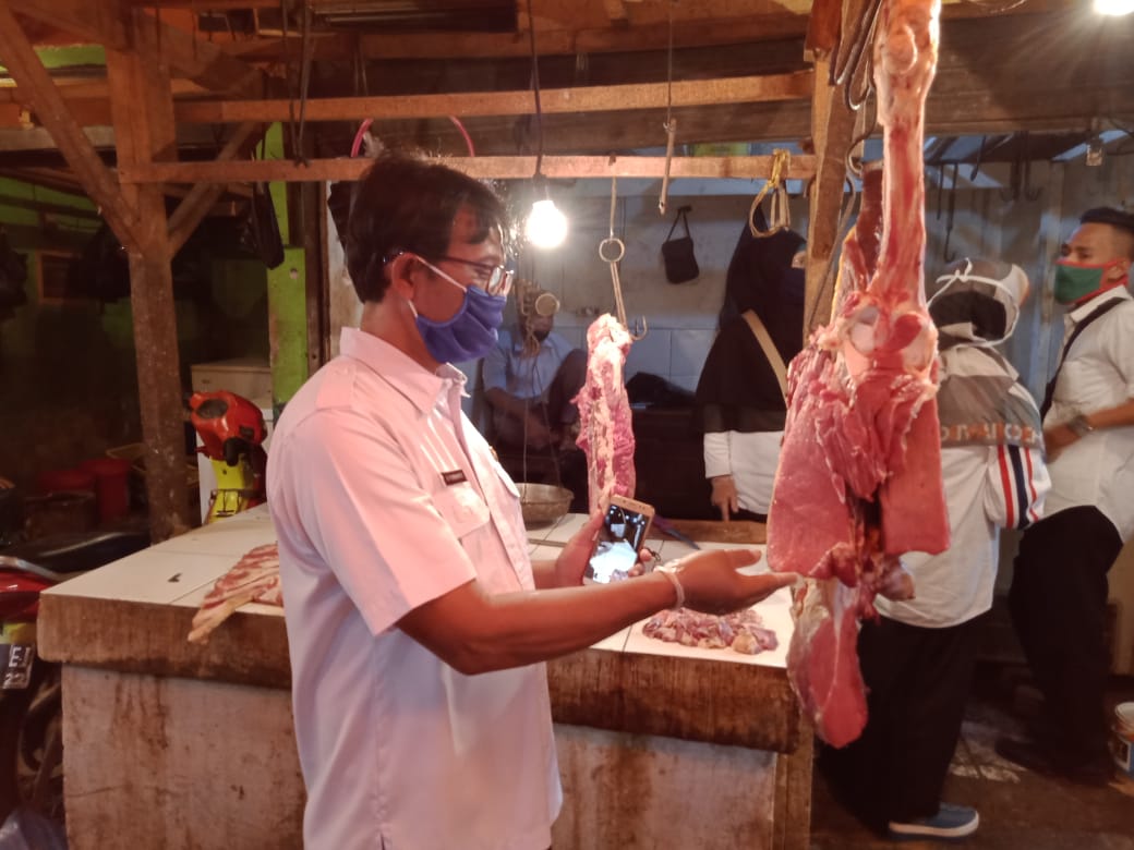 Petugas Dinas Pangan Kabupaten Karawang tengah memeriksa daging sapi yang dijual pedagang.
