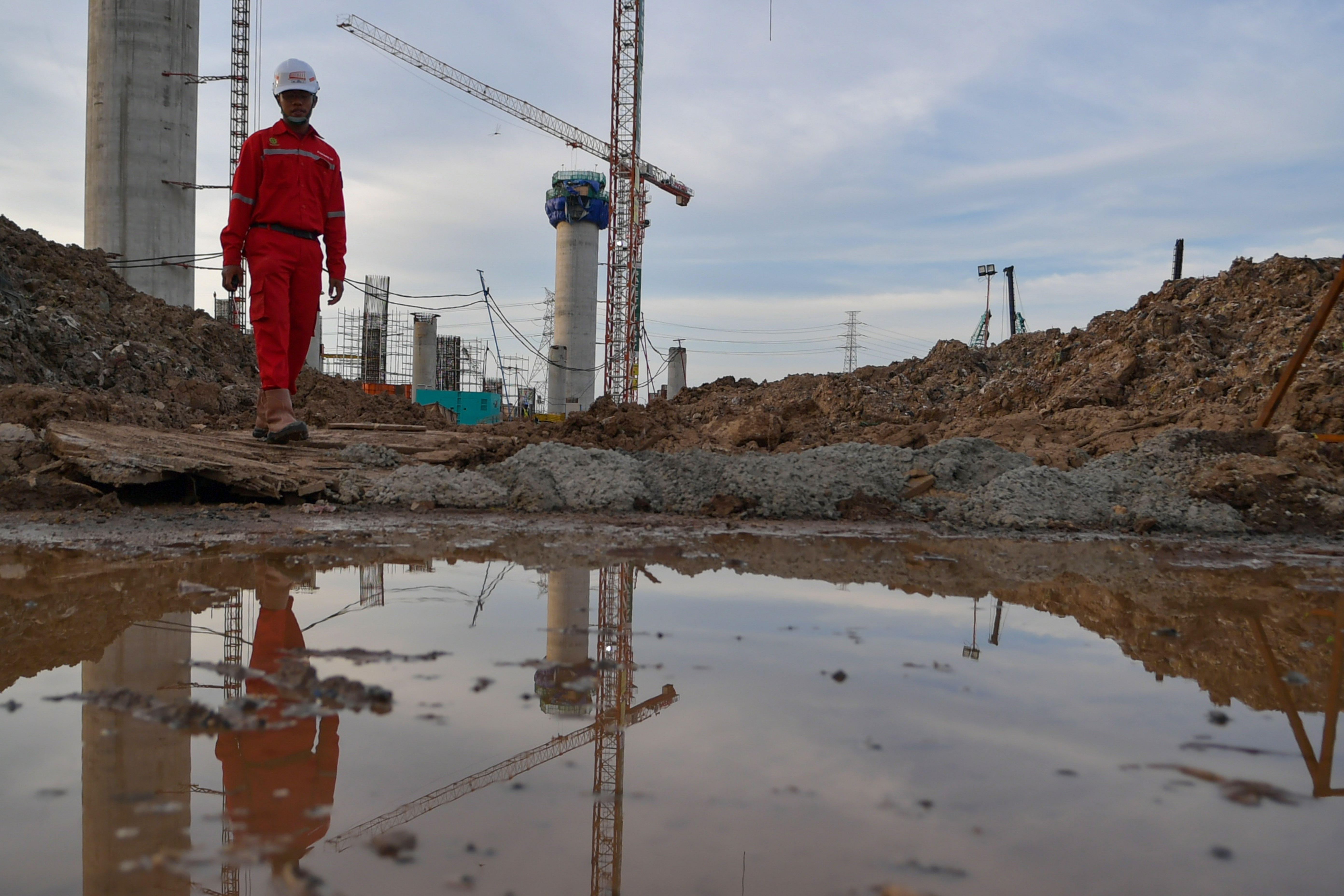 Pekerja melintasi proyek pembangunan Jakarta International Stadium di Tanjung Priok, Jakarta.