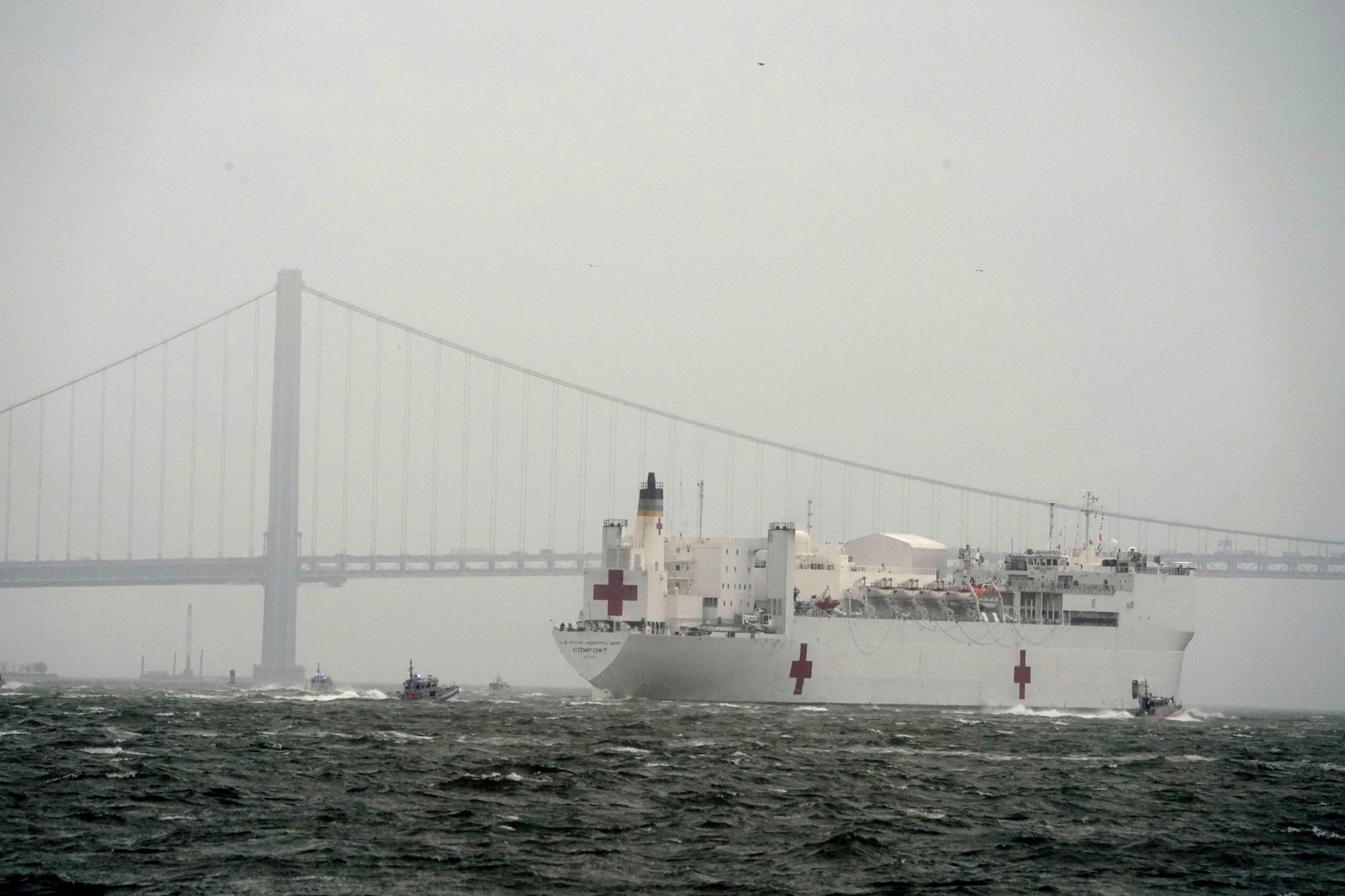 Kapal rumah sakit USNS Comfort melintas di bawah jembatan Verrazzano-Narrows saat meninggalkan New York setelah membantu penanganan covid-19