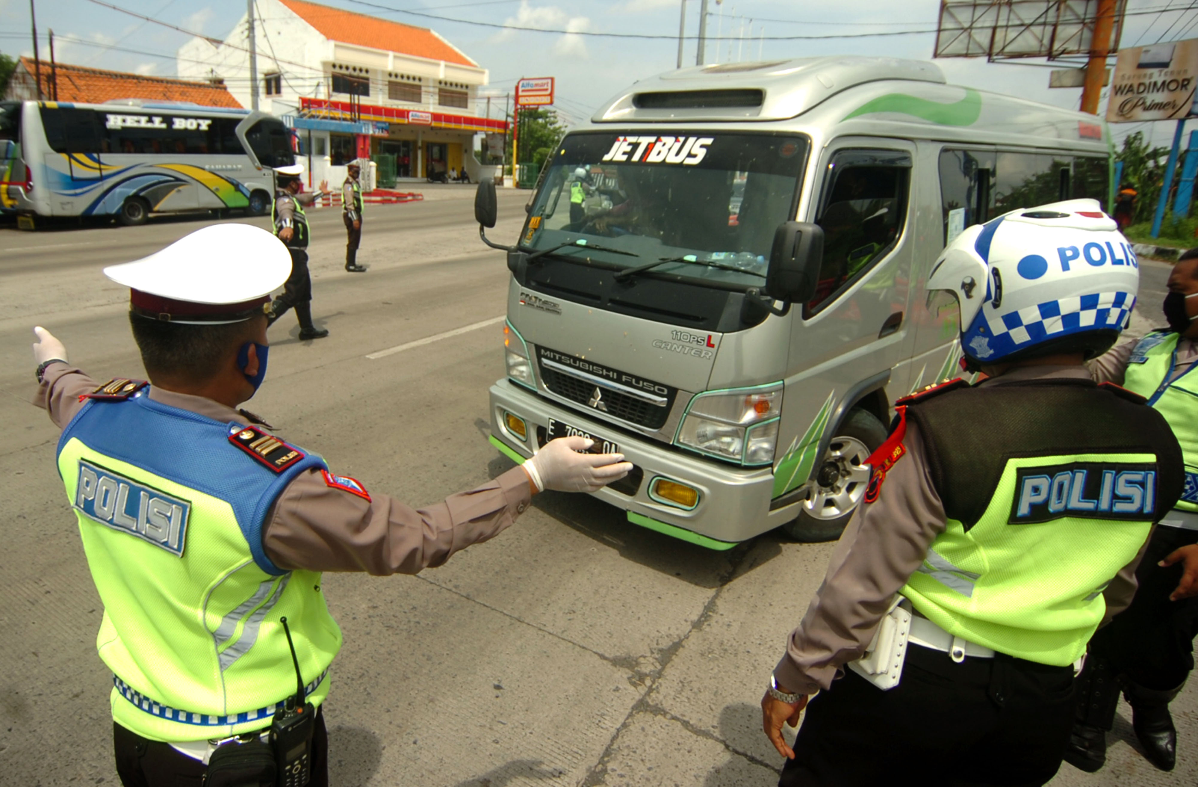 Petugas kepolisian memerintahkan mobil travel untuk memutar kembali ke arah Jakarta saat penyekatan di jalur Pantura, Tegal.
