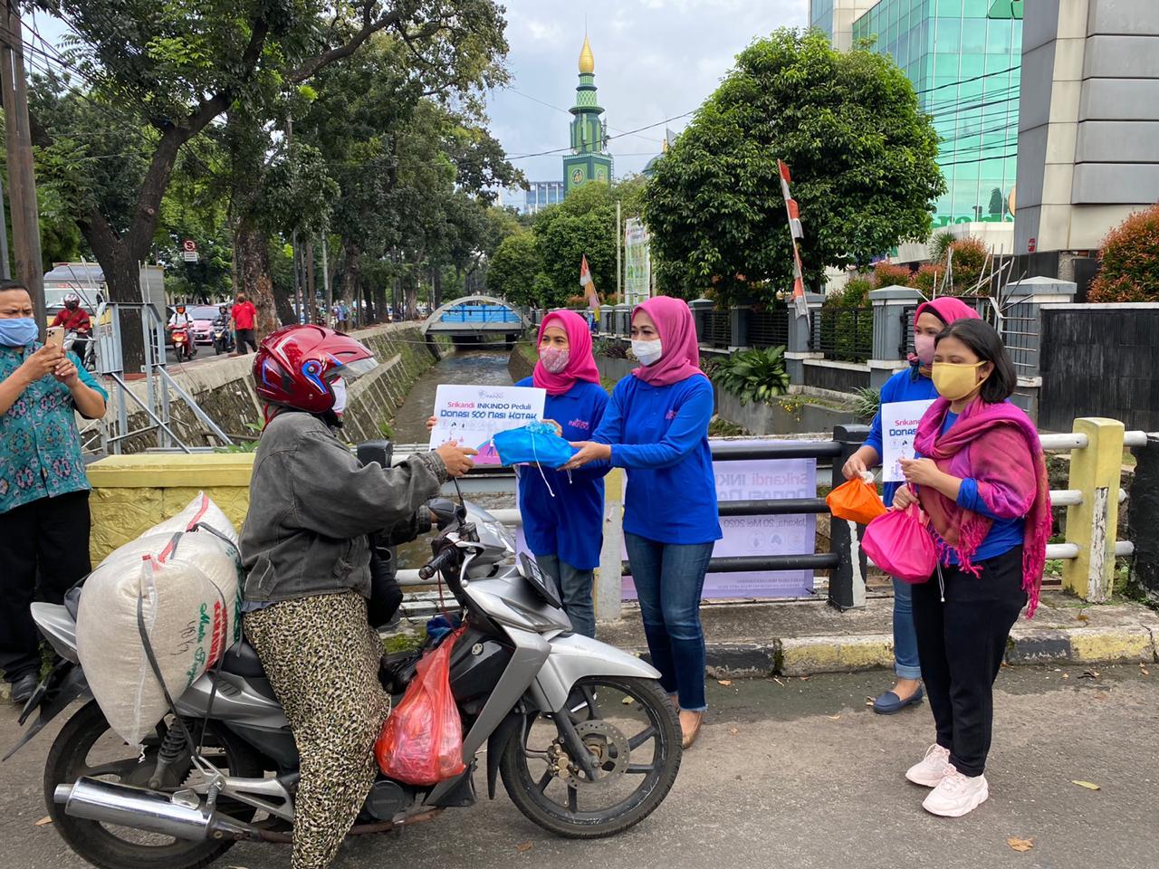Sejumlah anggota Srikandi Ikatan Nasional Konsultan Indonesia (Inkindo) tengah memberikan bantuan nasi kotak.