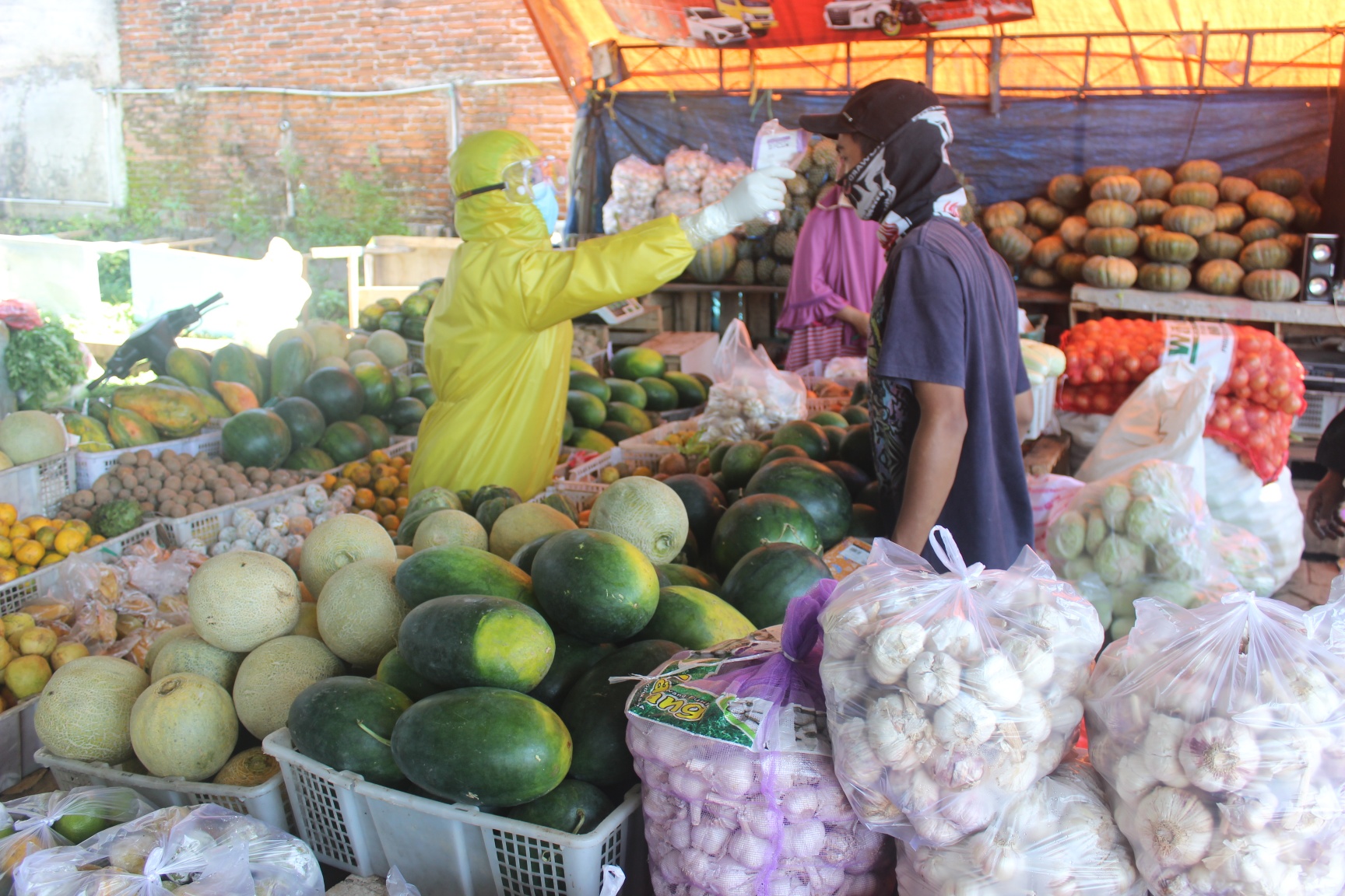 Petugas Dinas Kesehatan Kabupaten Malang, Jawa Timur, mengecek suhu tubuh pedagang sayur di Pasar Karangploso