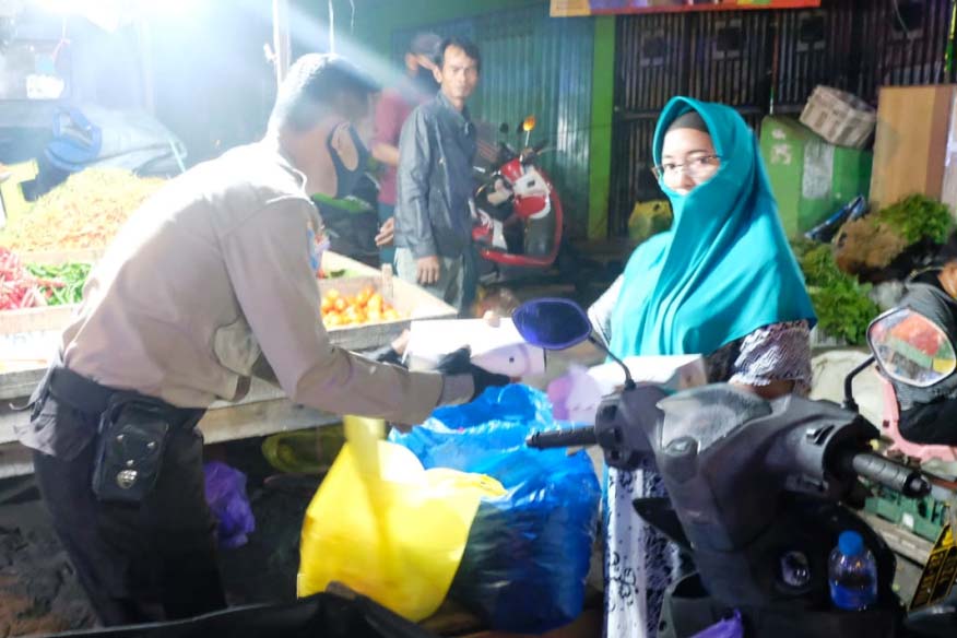 Personel Polda Kalteng bagikan nasi kotak di pasar subuh.