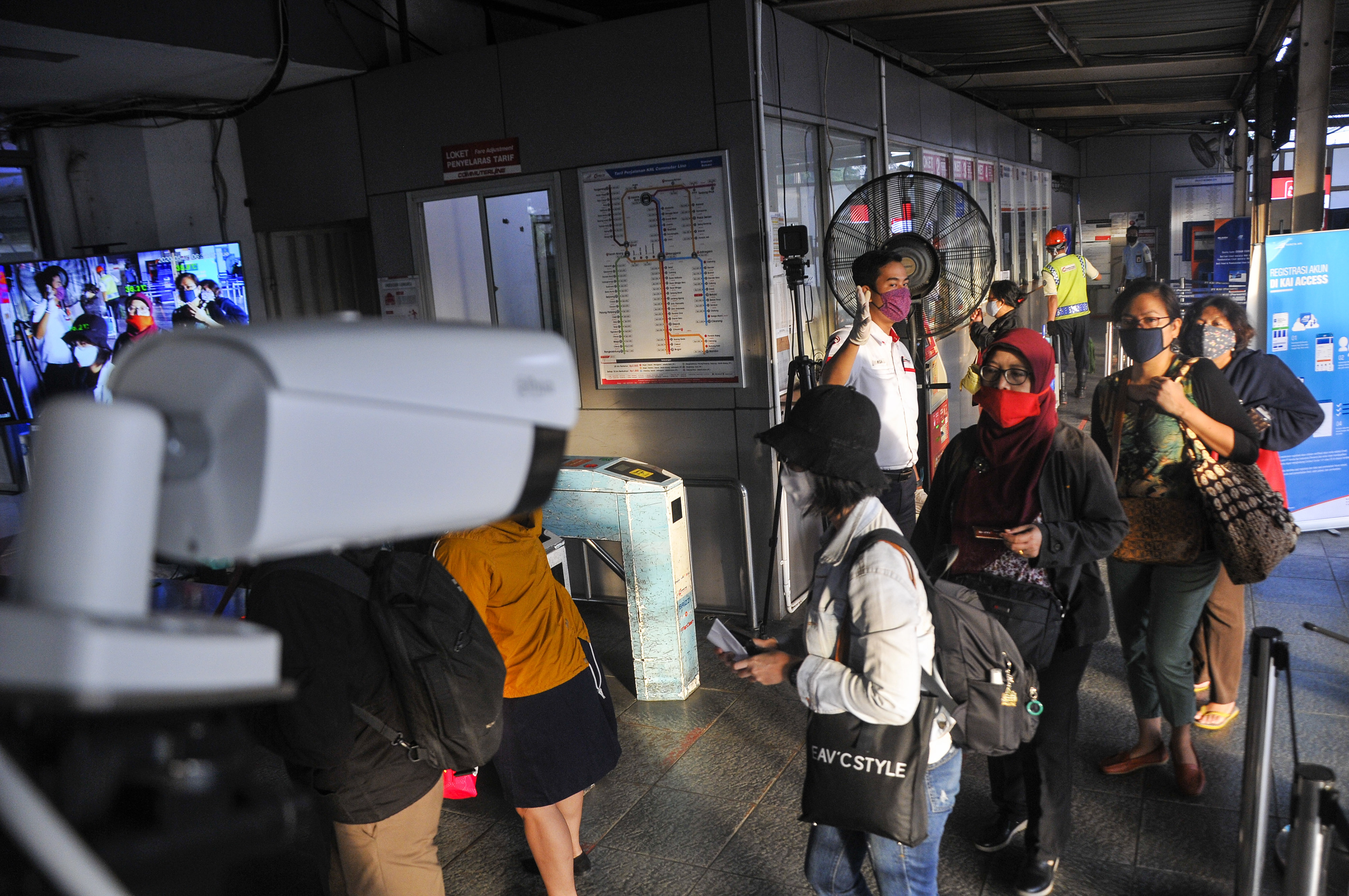 Sejumlah penumpang melintasi alat pendeteksi suhu tubuh (thermal scanner) di Stasiun Bekasi.