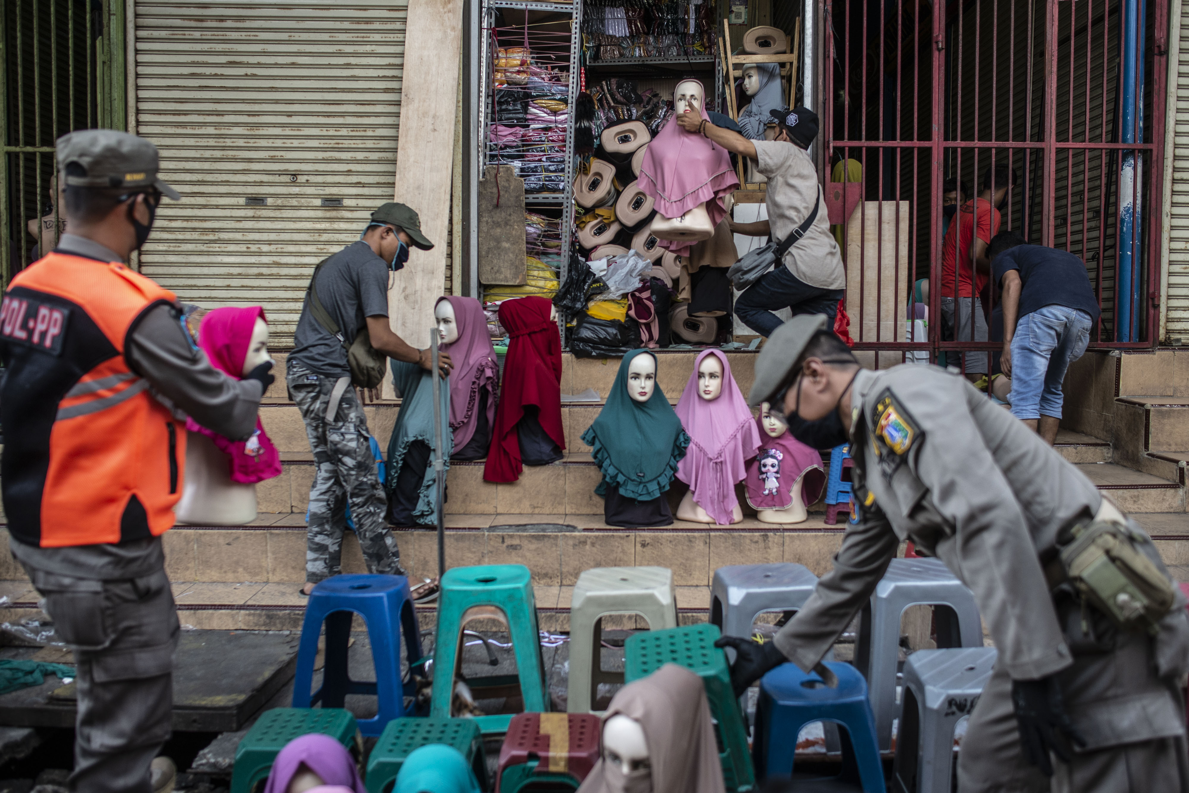Petugas Satpol PP membantu pedagang mengemas barang dagangan di kawasan Pasar Tanah Abang, Jakarta, Sabtu (23/5). 