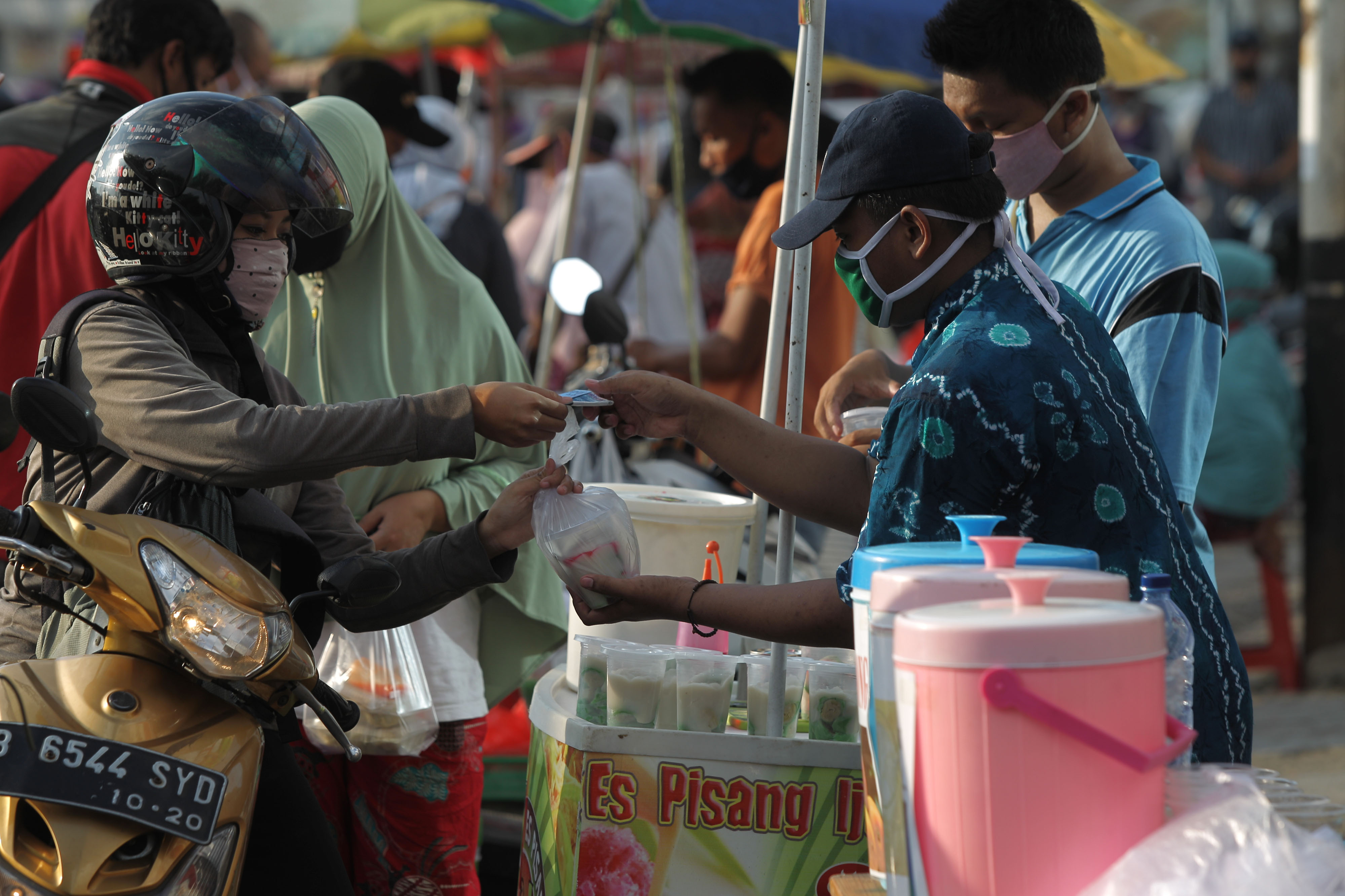 Pedagang melayani pembeli takjil di kawasan Jalan Panjang, Kebon Jeruk, Jakarta barat, Minggu (3/5).   