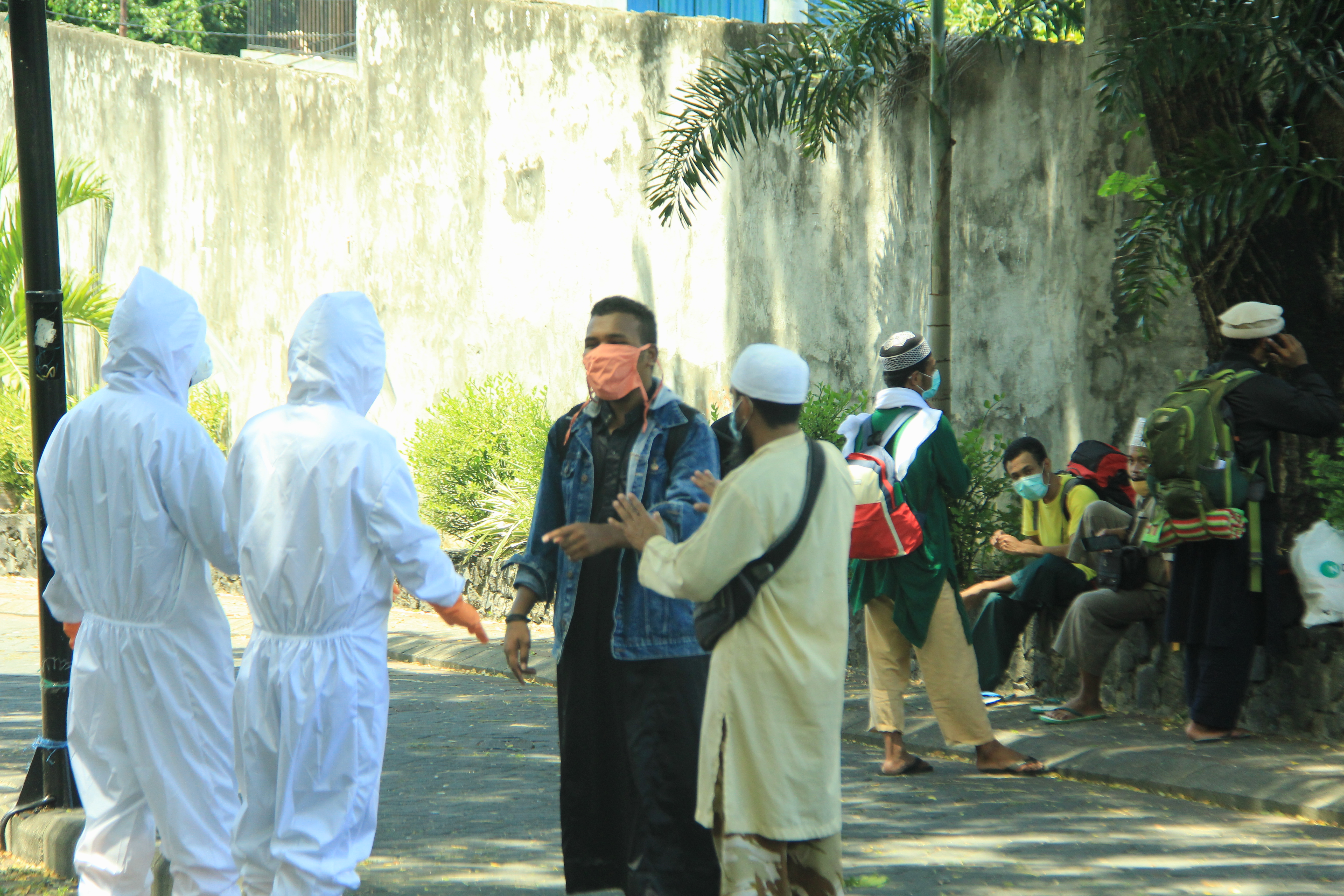 Petugas dengan APD lengkap sedang bernegosiasi dengan pasien yang kabur dari tempat karantina di Ternate
