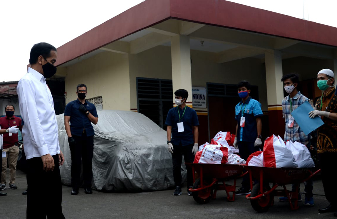 Presiden Joko Widodo meninjau proses pendistribusian sembako tahap ke-3 kepada para KPM di Kecamatan Johar Baru, Jakarta, Senin (18/5).