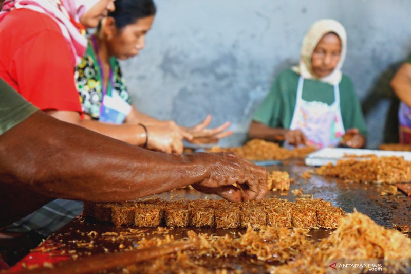 Pekerja memproduksi jajanan tradisional 