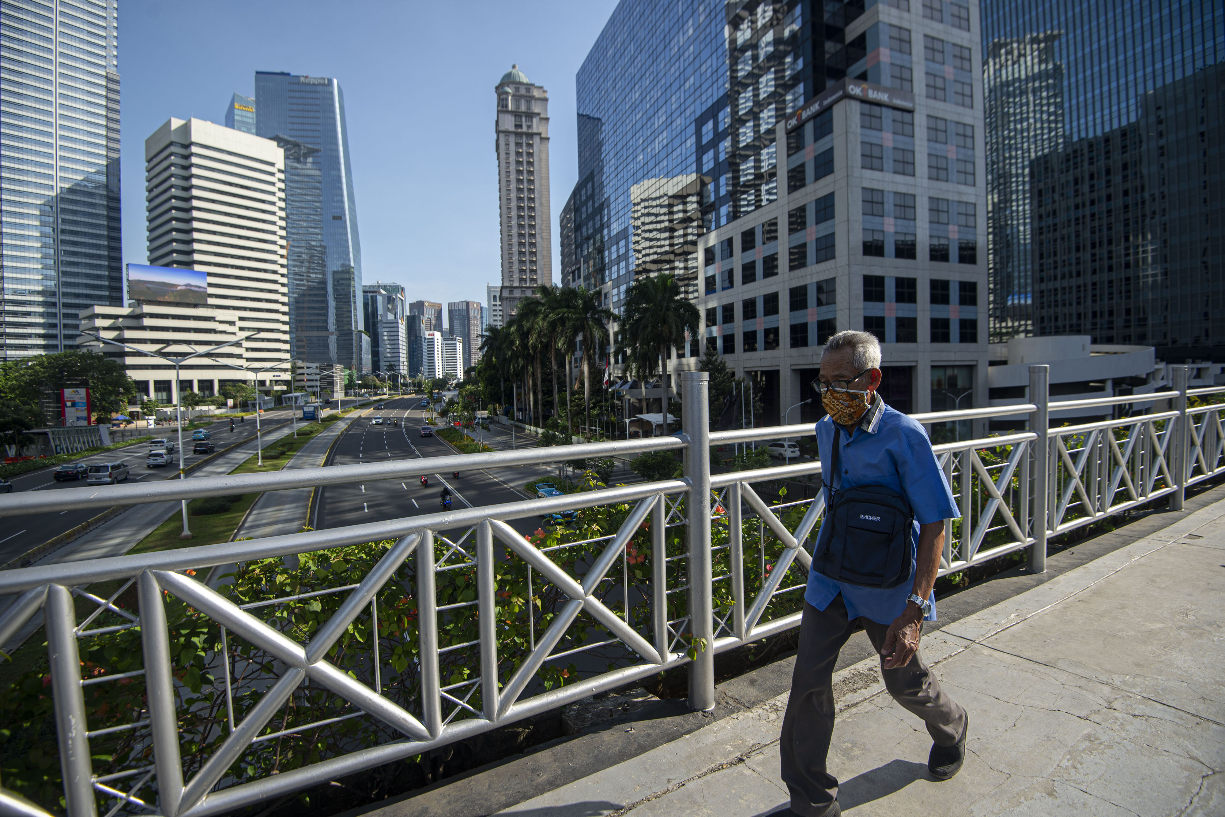 Warga dengan mengenakan masker berjalan di salah satu jembatan penyeberangan orang (JPO) di Jalan Sudirman, Jakarta, Sabtu (16/5/2020)