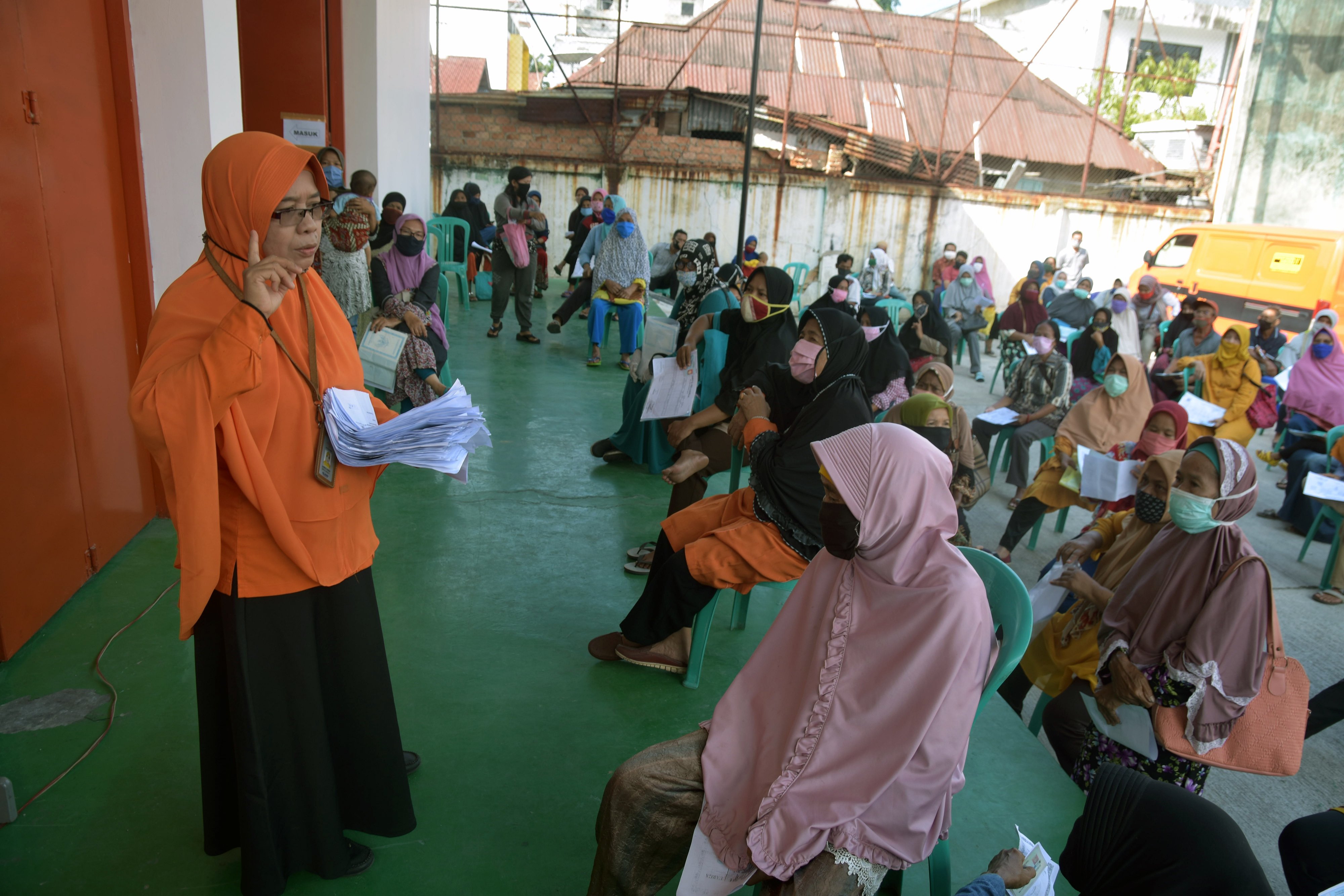 Seorang petugas Kantor Pos (kiri) menjelaskan prosedur pencairan dana Bantuan Sosial Tunai (BST) di Kantor Pos Pekanbaru, Riau, Selasa (12/5