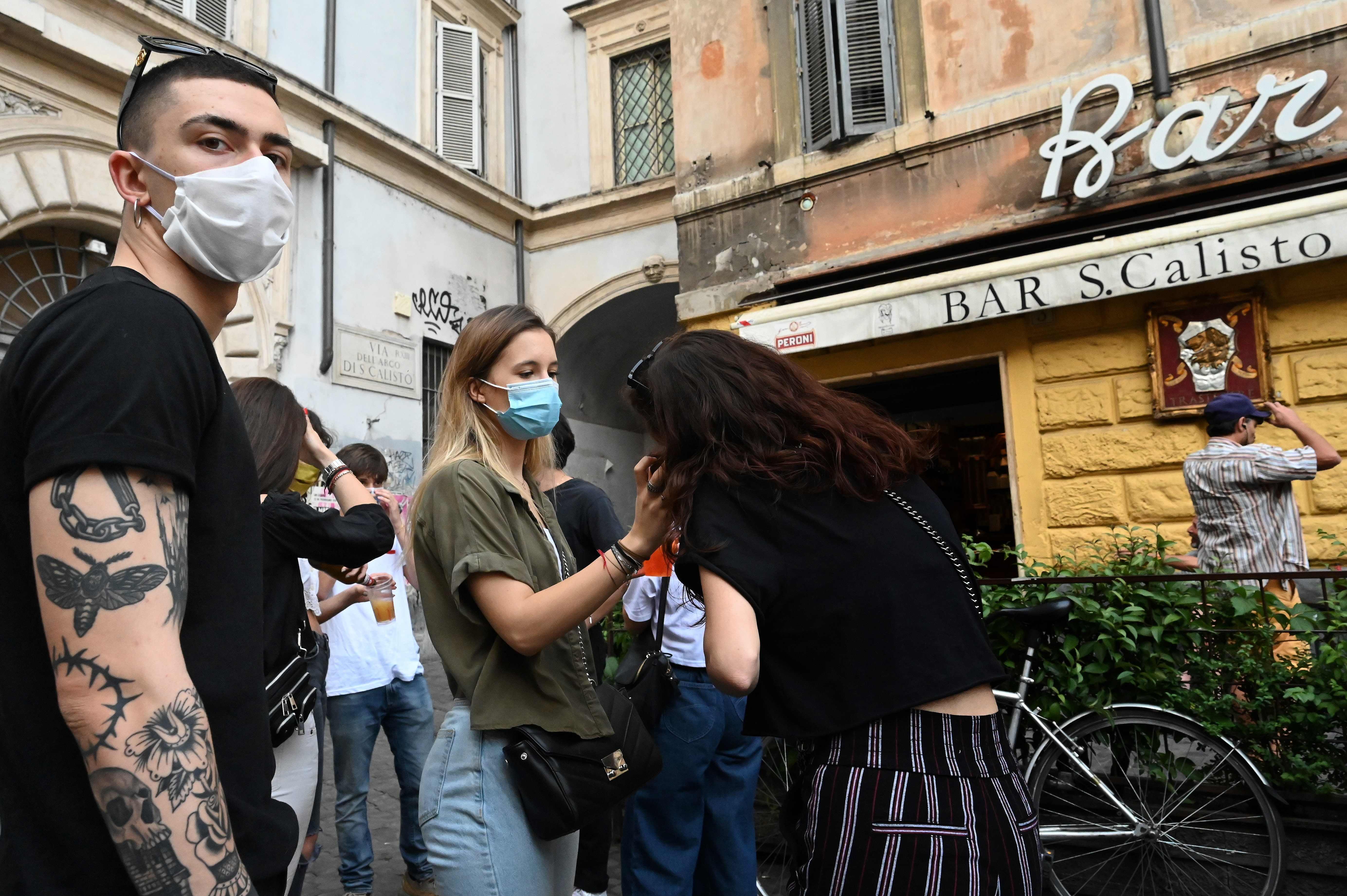 Kaum muda berkumpul di luar bar di distrik Trastevere di Roma, Italia, Senin (18/5), saat pemerintah melonggarkan Lockdown.