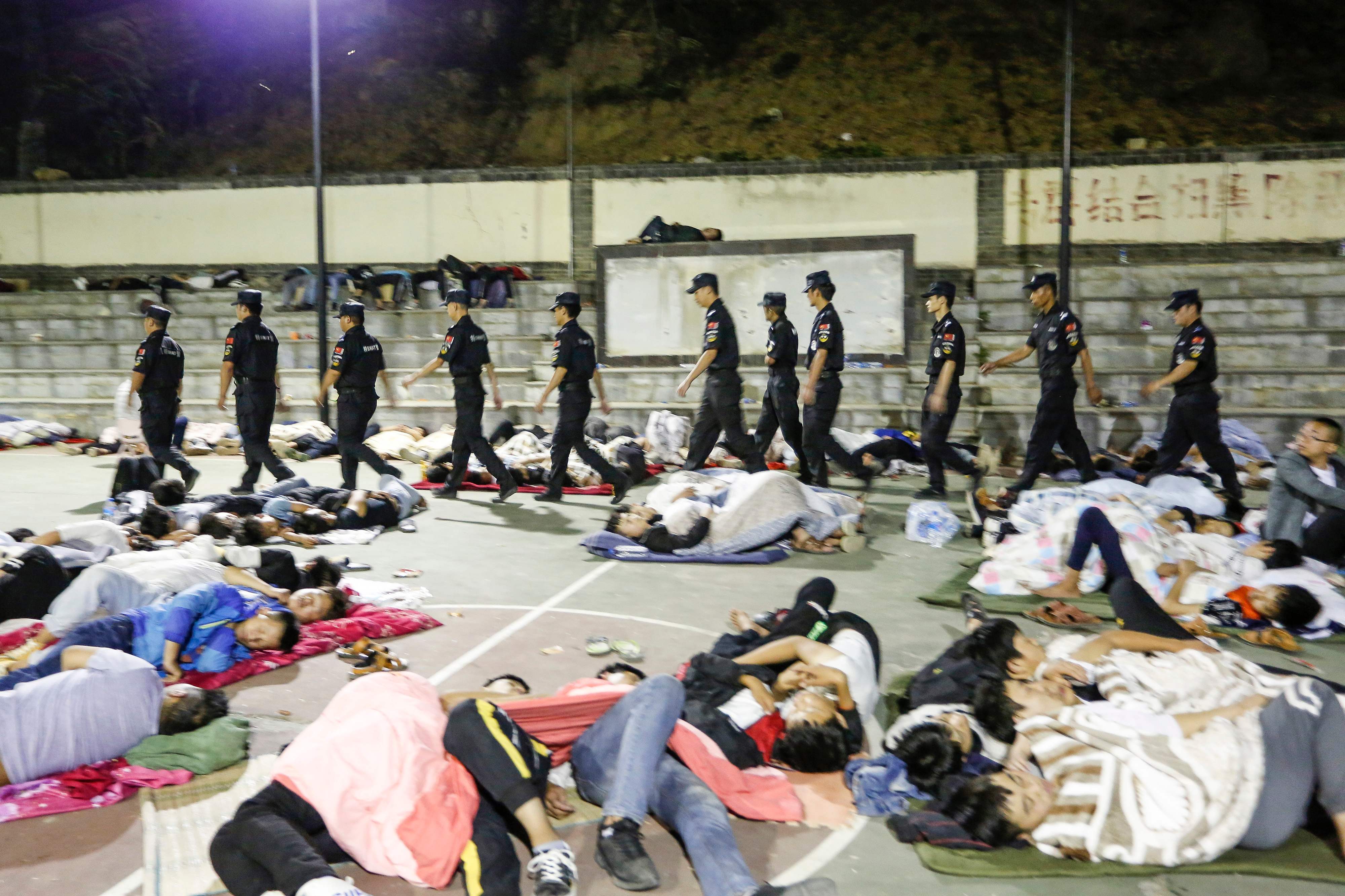 Polisi berpatroli di lokasi pengungsian warga korban gempa di Kabupaten Qiaojia, Provinsi Yunnan, Tiongkok.