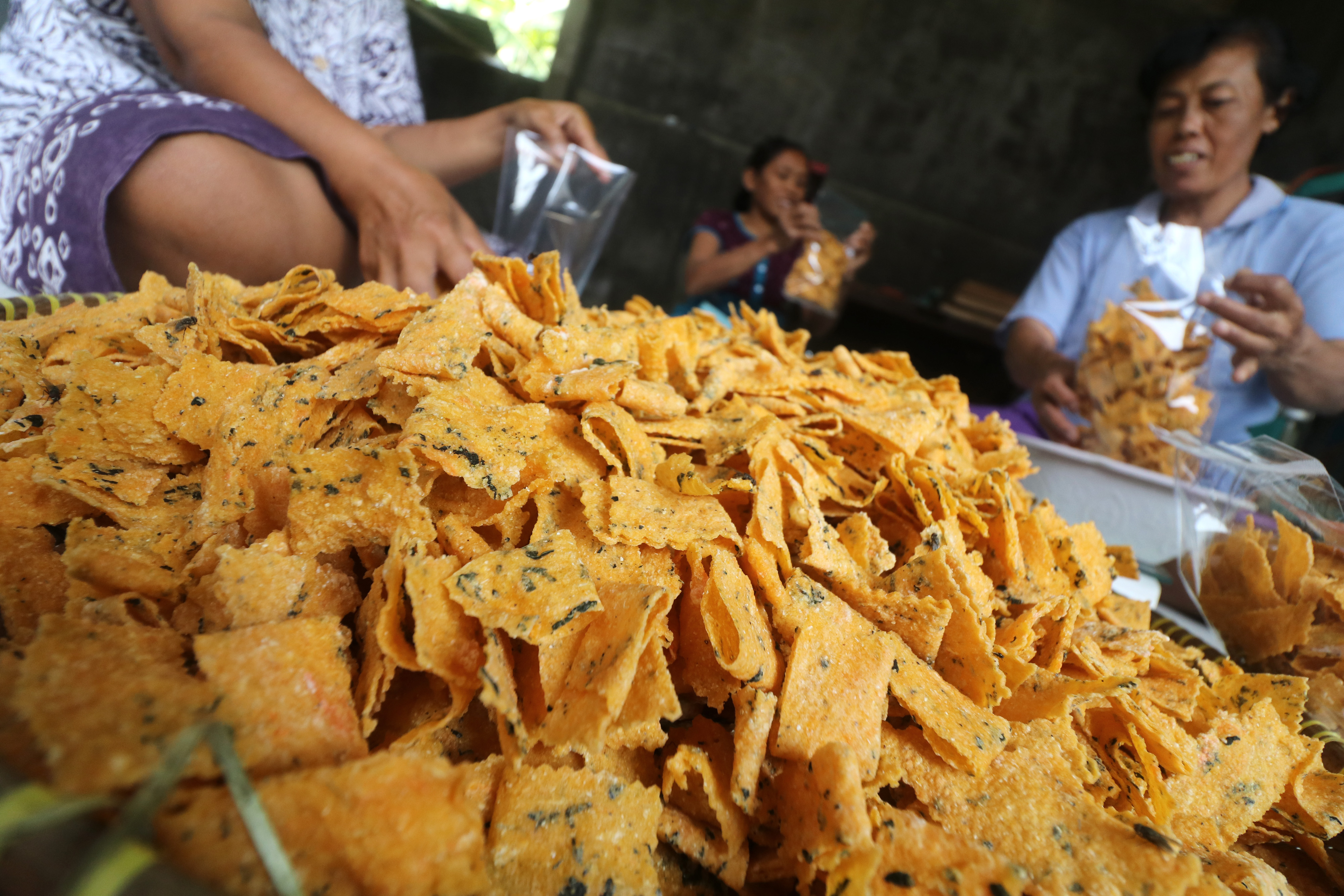 Pekerja memasukkan kerupuk yang terbuat dari ampok (nasi jagung) ke dalam kantong plastik di Desa Nanggungan, Kediri, Jawa Timur.