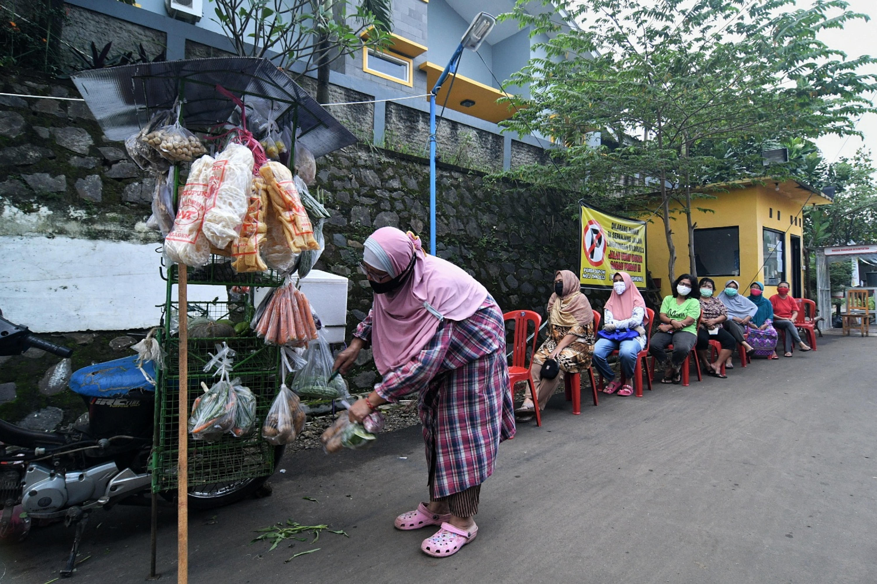 Mengantisipasi penyebaran covid-19, warga menjaga jarak fisik saat berbelanja.