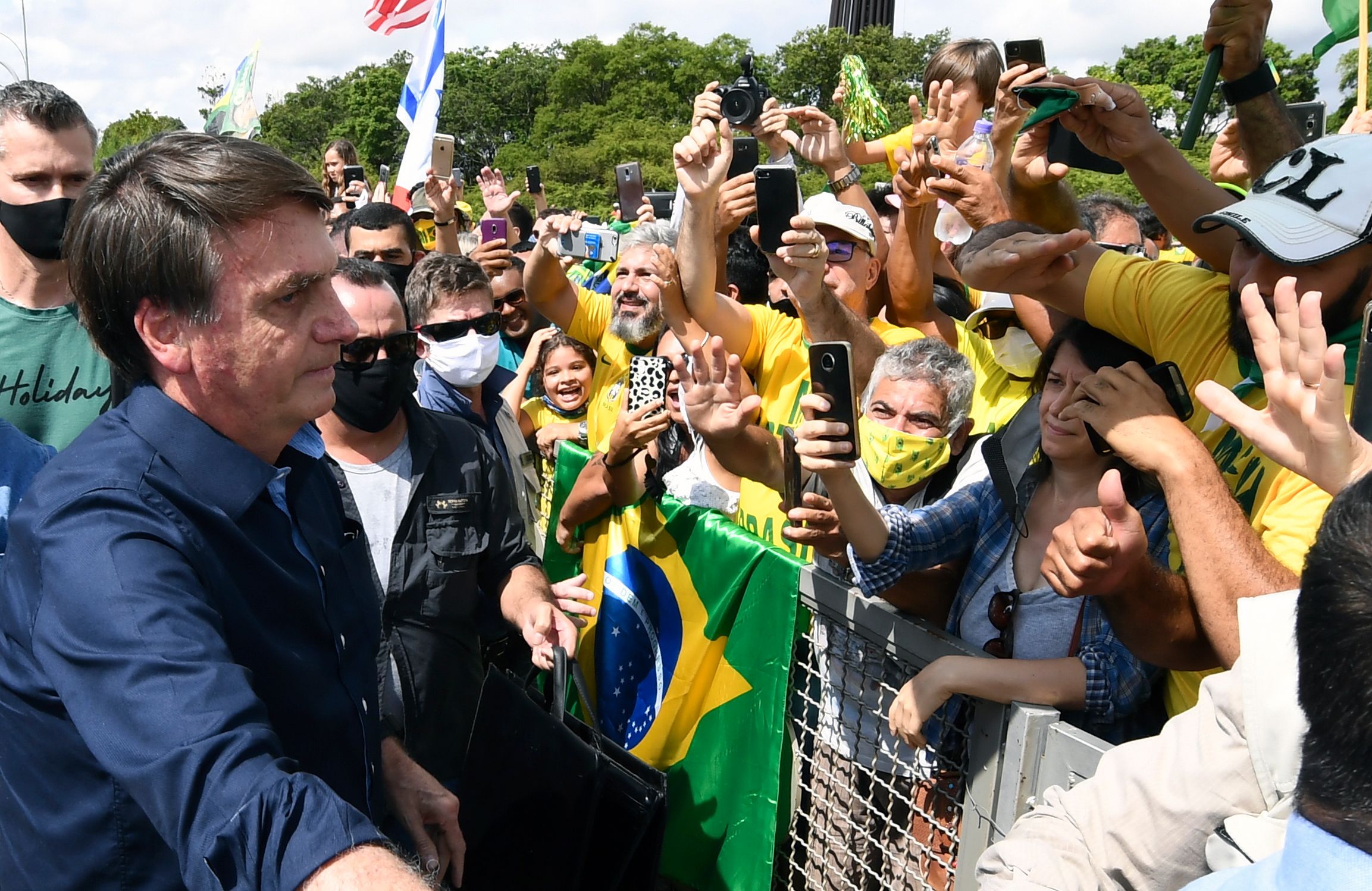 Presiden Brasil Jair Bolsonaro menyapa para pendukungnya di luar Istana Planalto, Brasilia.