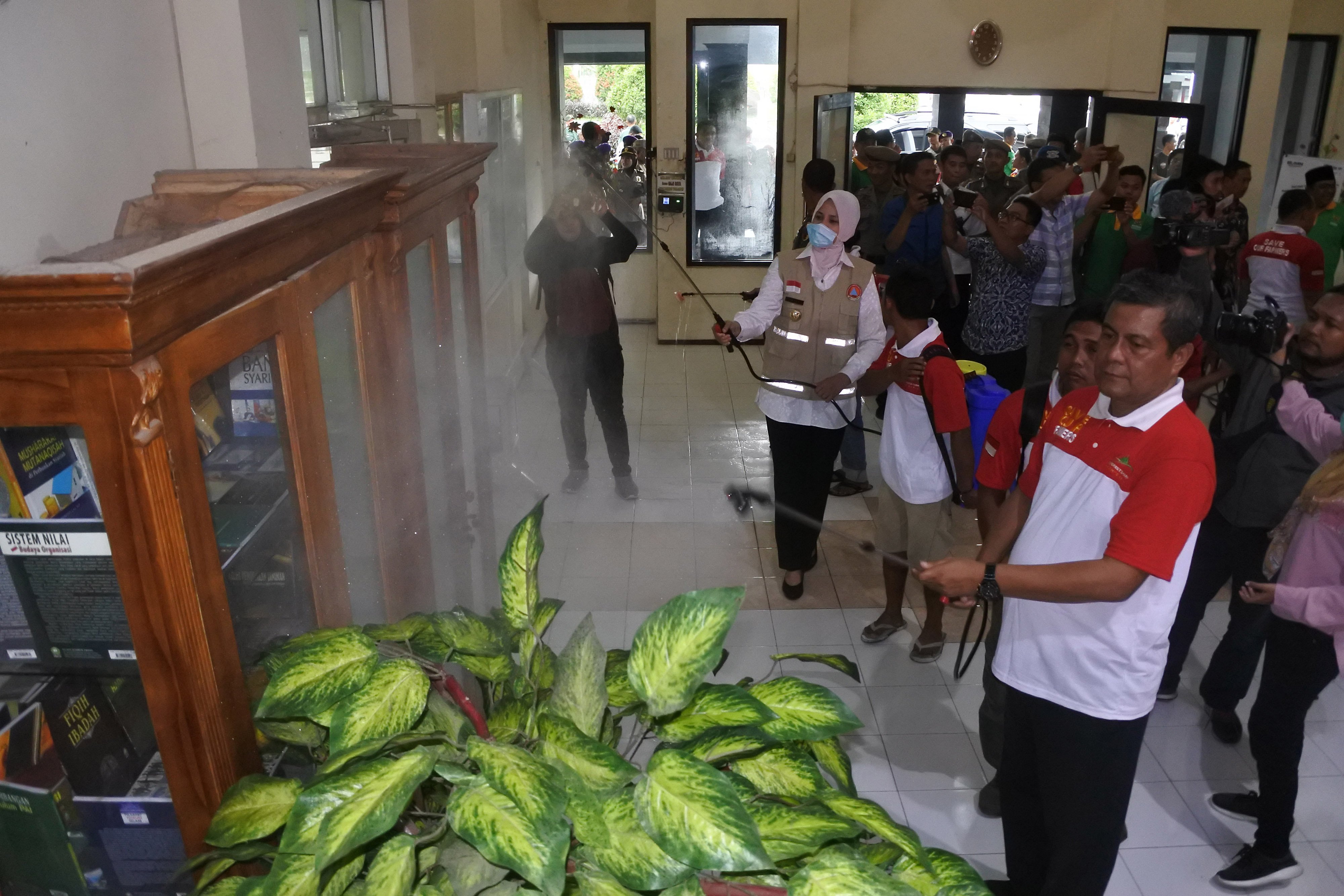 Bupati Jember Faida menyemprotkan disinfektan di Kampus IAIN Jember. Bawaslu Jatim temukan politisasi bansos covid-19 oleh petahana.