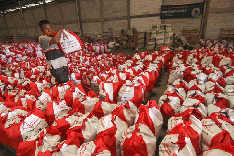Pekerja menata bantuan paket sembako untuk dibagikan ke masyarakat Keluarga Penerima Manfaat (KPM) yang terdampak pandemi covid-19