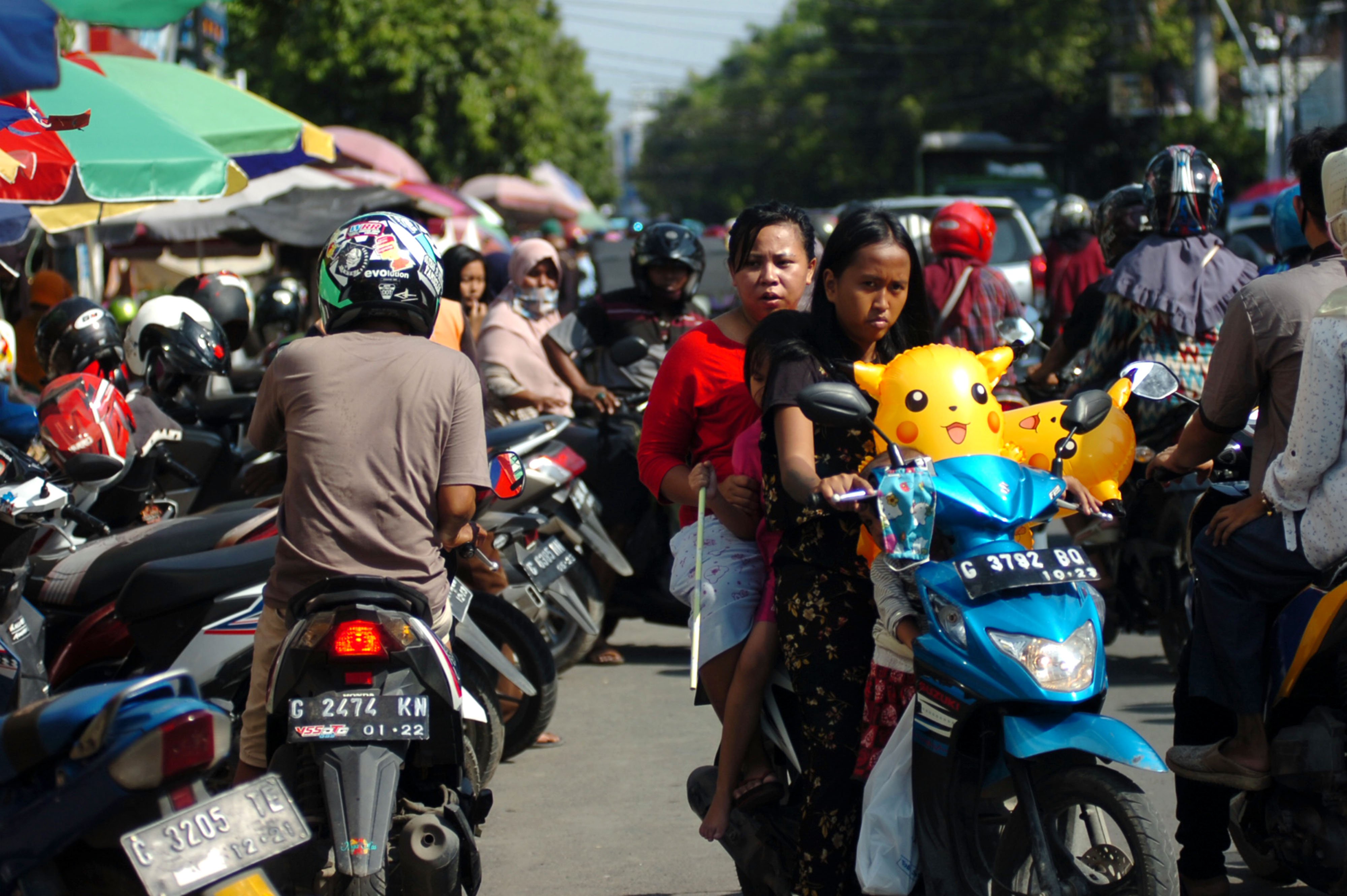 Warga berkendara motor tanpa menggunakan helm dan masker di Jalan Ahmad Yani, Tegal, Jawa Tengah, Sabtu (23/5).