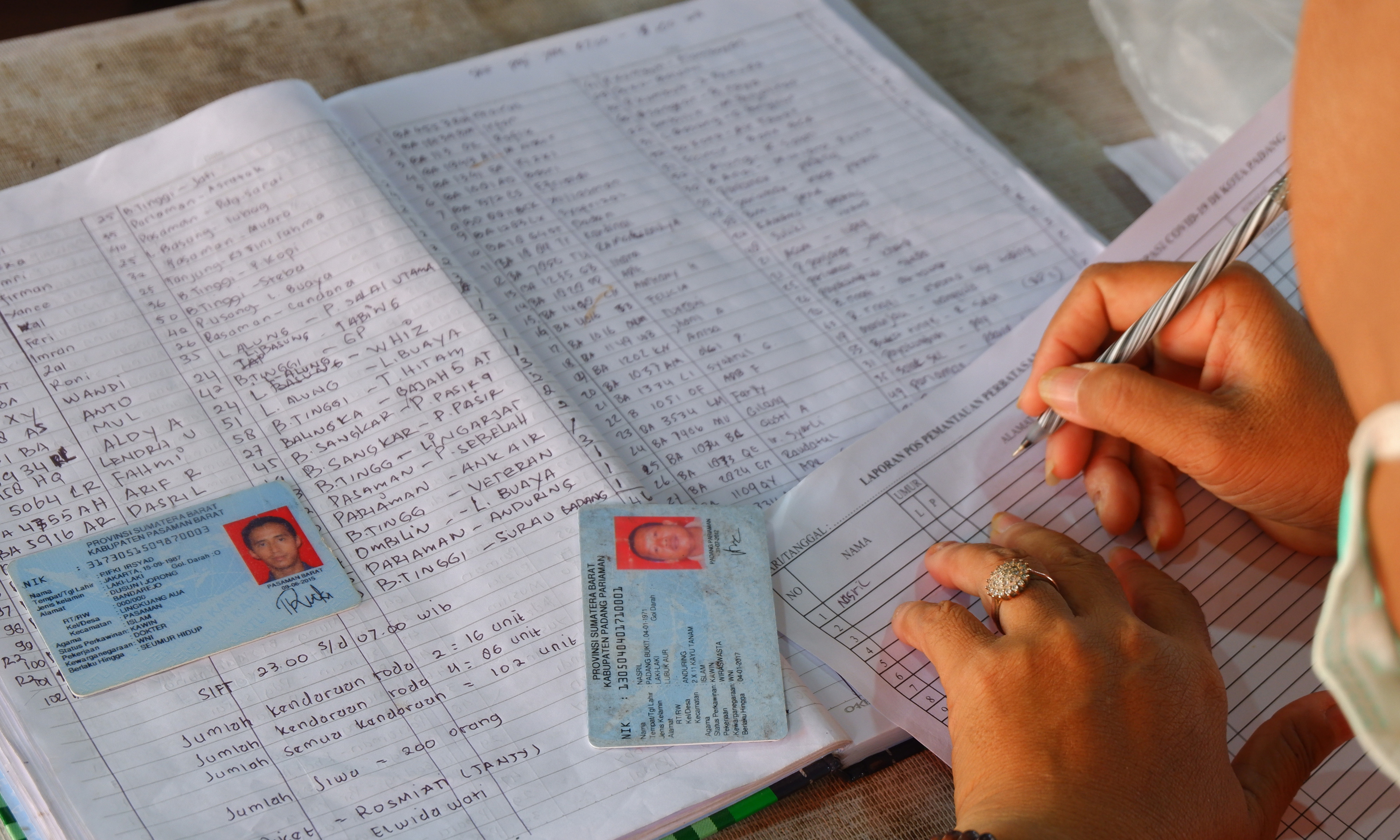  Petugas mencatat data pemilik KTP elektronik pendatang yang disita, di Posko Pemeriksaan Kayu Kalek, batas kota Padang, Sumatera Barat, Min