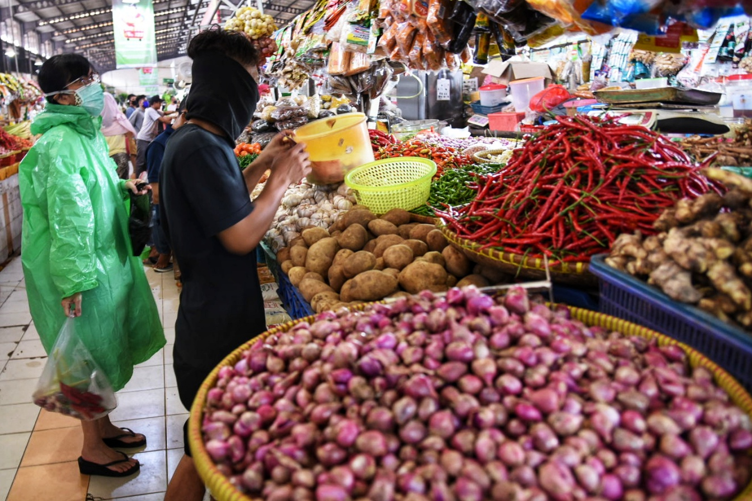 Pedagang sayur melayani pembeli di Pasar Delapan Alam Sutera, Tangerang, Banten.