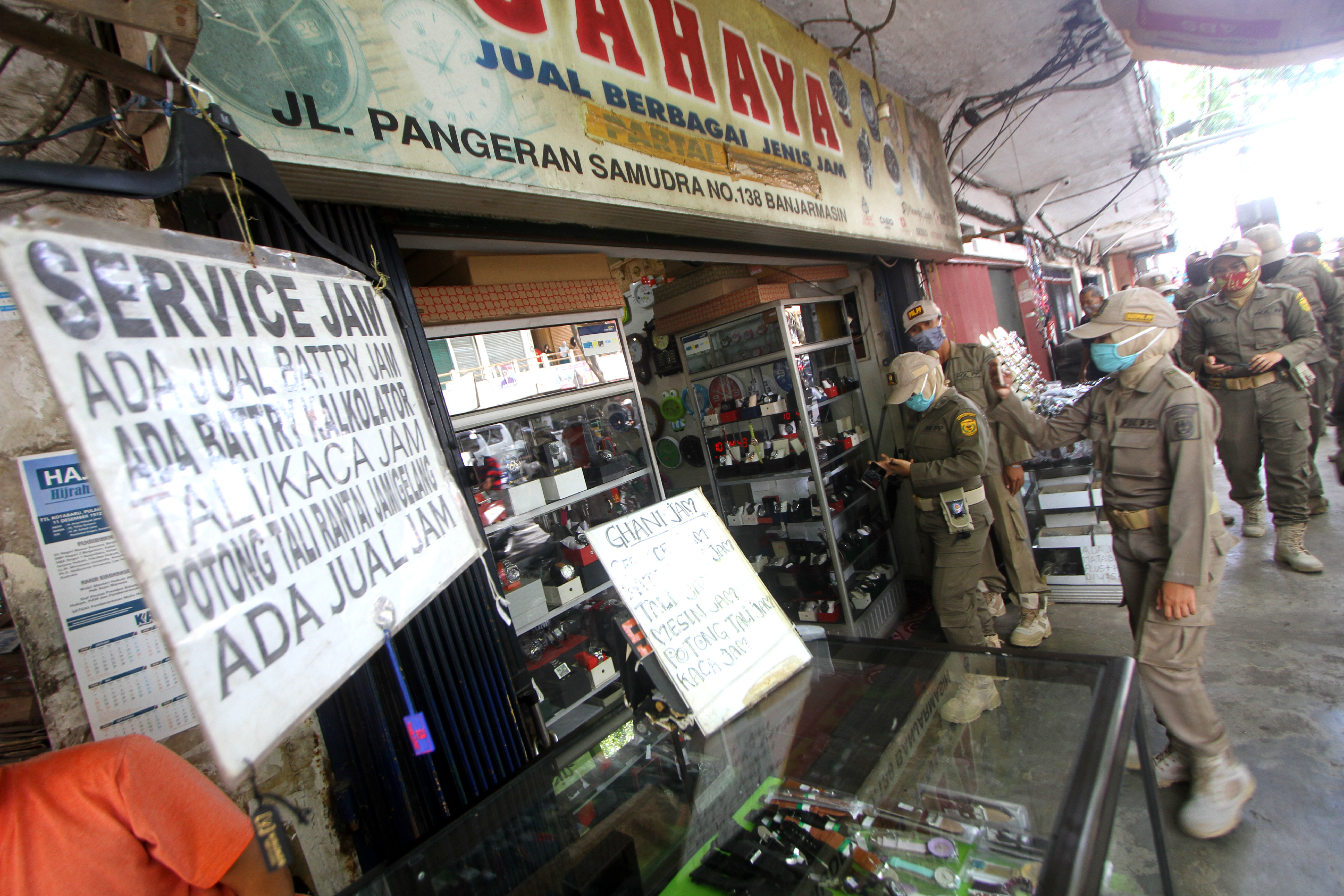 Petugas Satpol PP mengimbau  kepada pedagang yang masih membuka toko saat pemberlakuan PSBB di Pasar Sudimampir Banjarmasin, Kalsel.