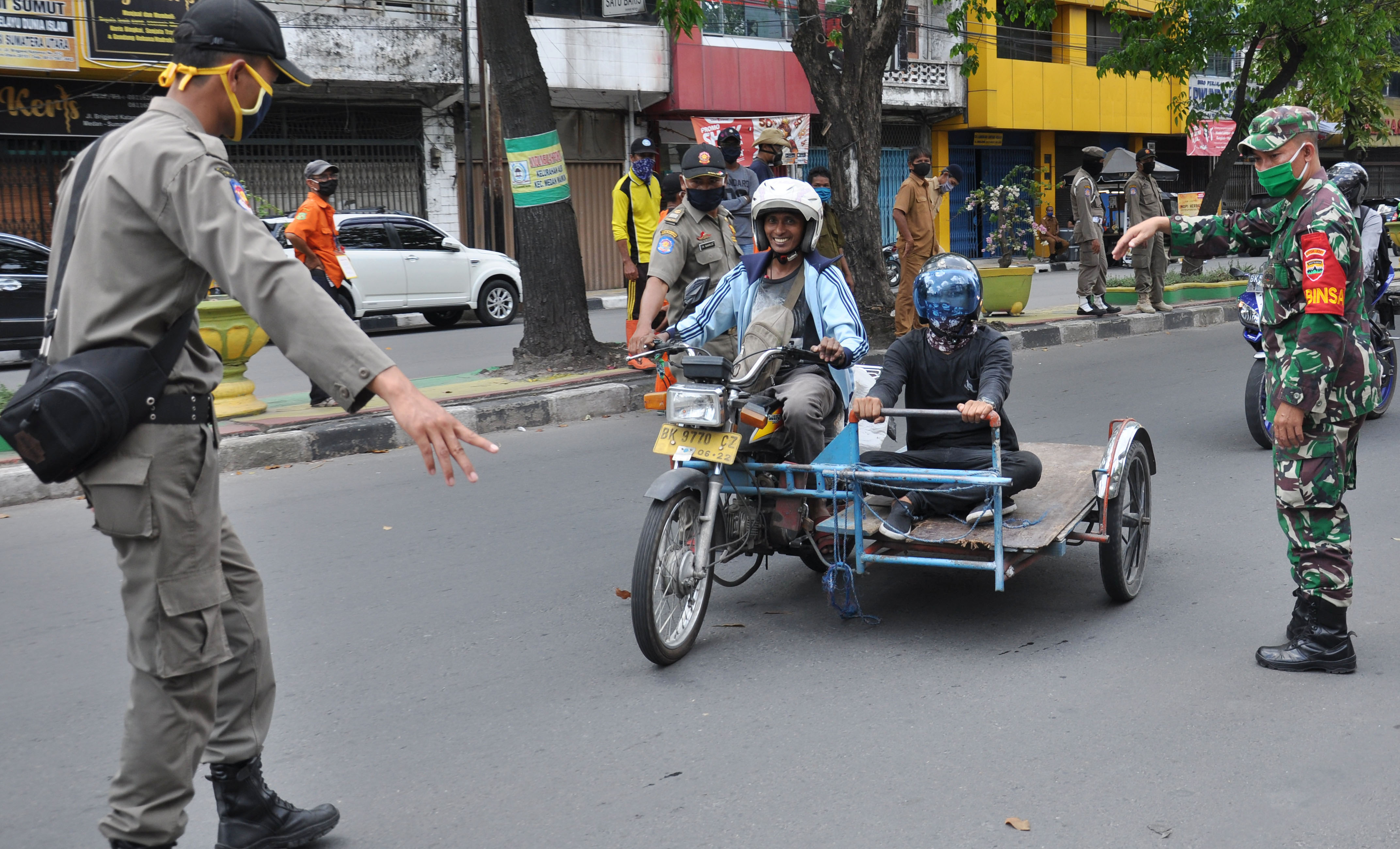 Petugas gabungan menghentikan warga yang tidak menggunakan masker ketika razia penggunaan masker di Medan, Sumatera Utara, Rabu (6/5). 