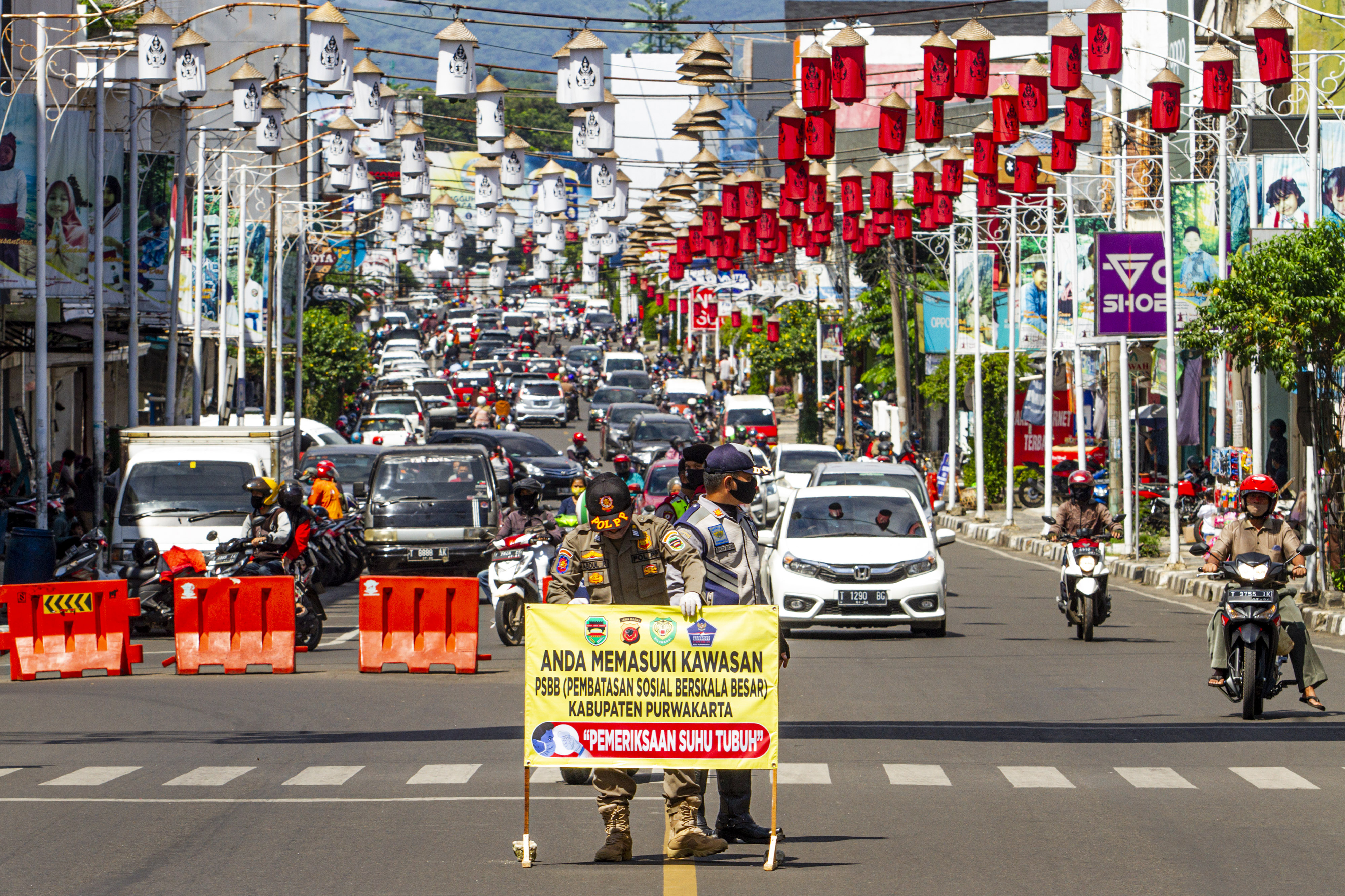  Petugas gabungan memasang pemberitahuan pemeriksaan penerapan Pembatasan Sosial Berskala Besar (PSBB) di Purwakarta, Jawa Barat, Senin (11/