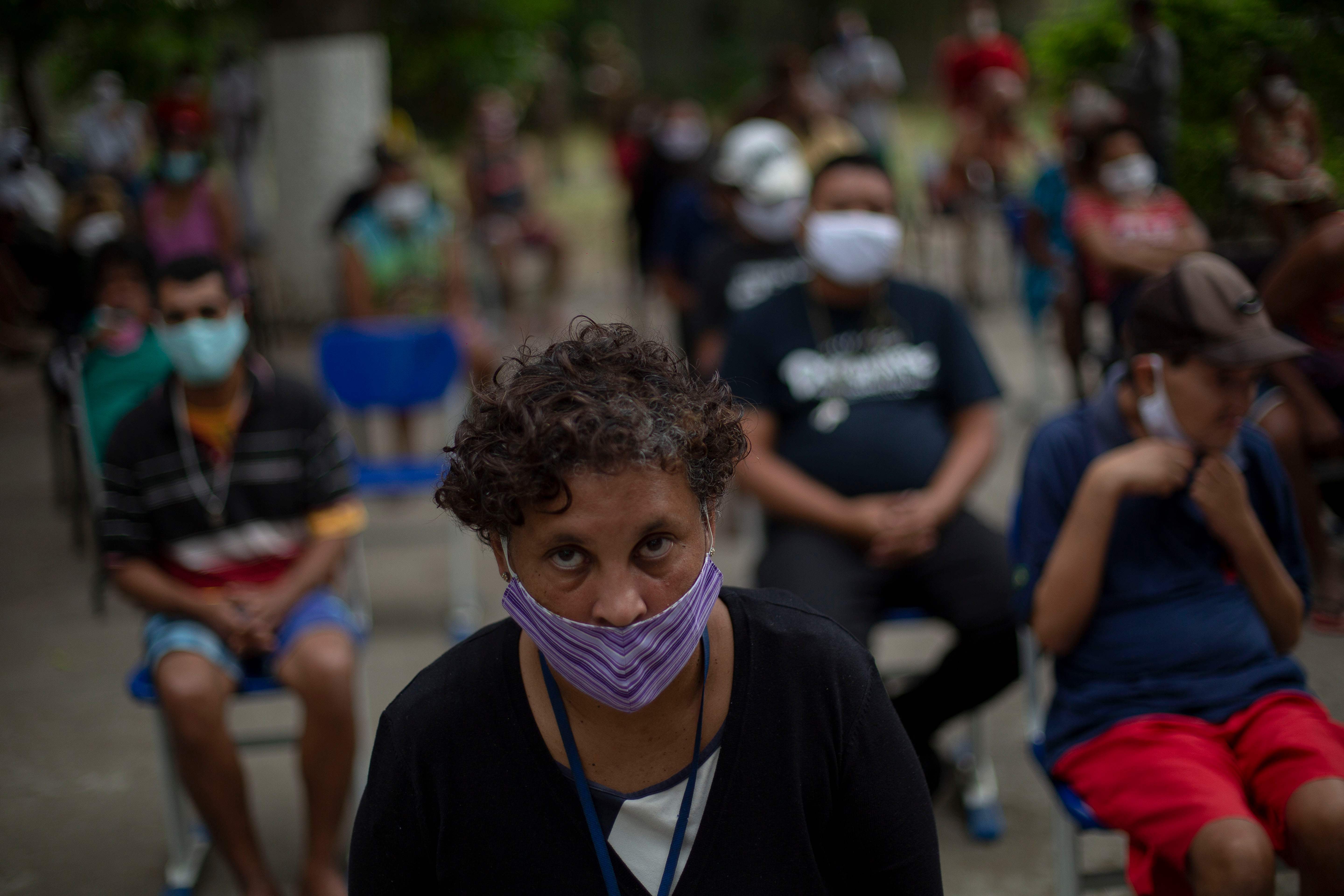 Warga yang tinggal di tempat penampungan Stella Maris, Rio de Janeiro menunggu saat tempat itu didisinfektasi oleh militer.