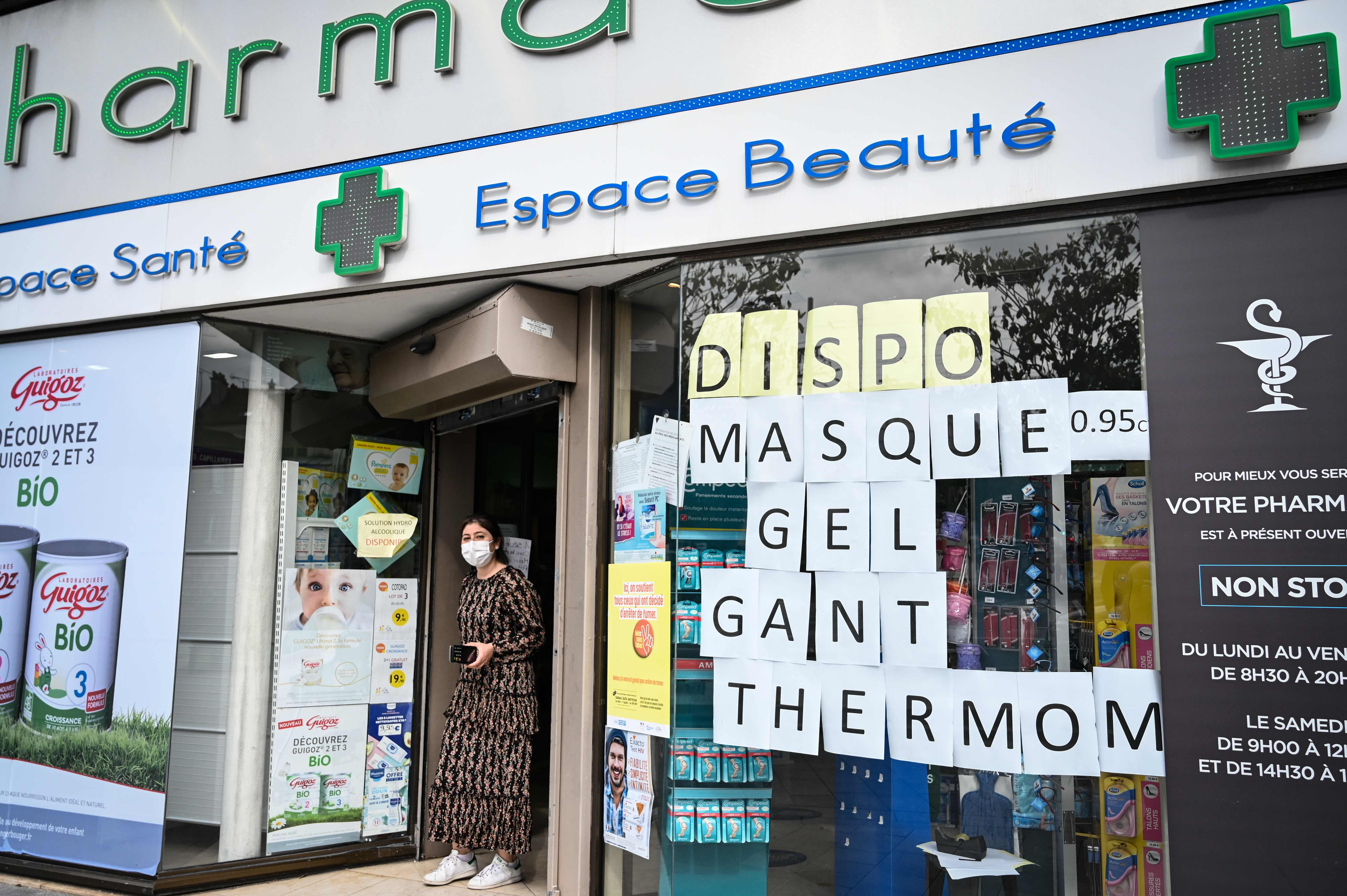  Seorang wanita mengenakan masker wajah berjalan keluar dari apotek di Le Perreux-sur-Marne, timur Paris, Senin (4/5).
