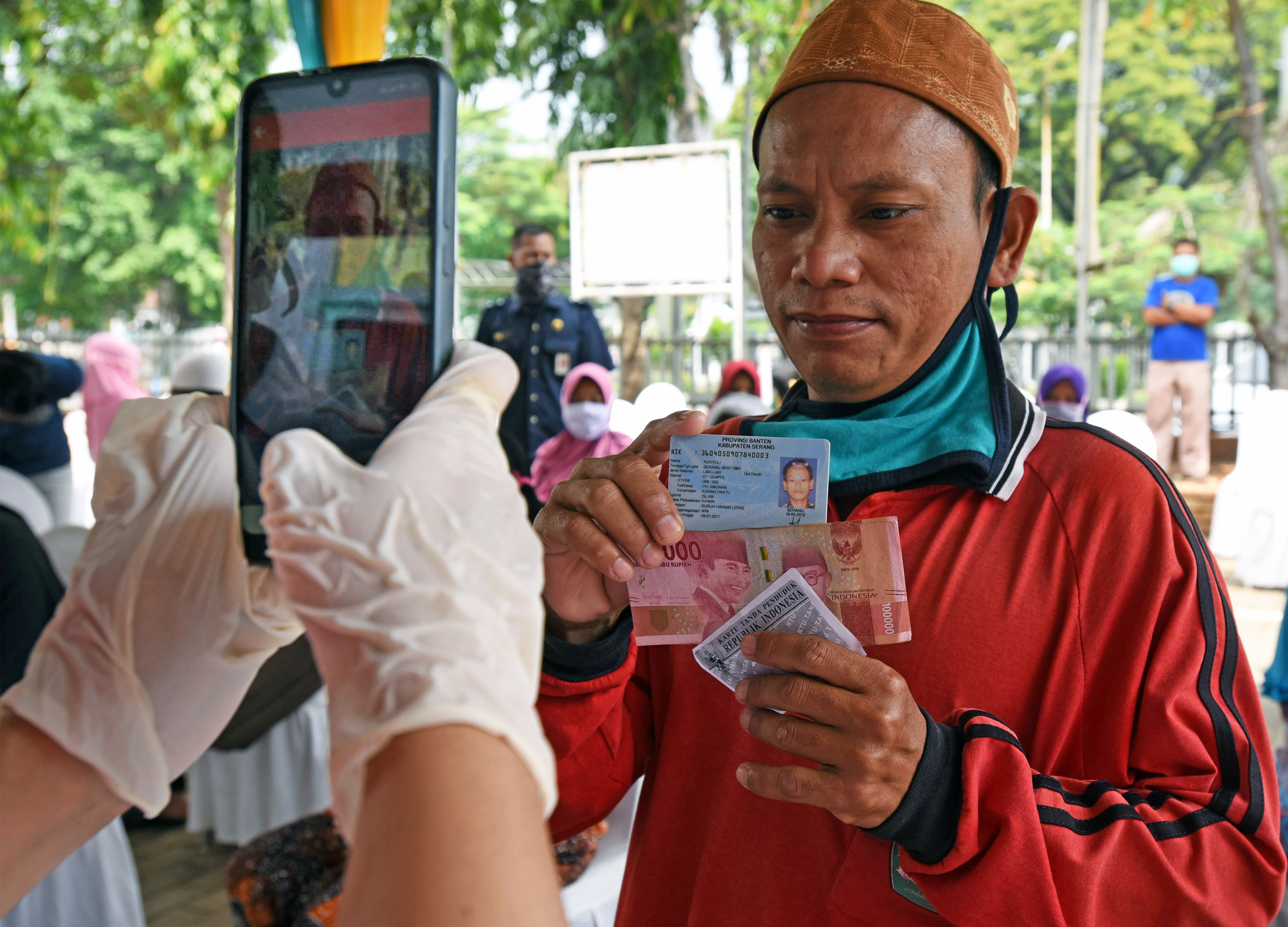 Petugas memotret warga penerima bansos tunai di Kantor Pos Serang, Banten.
