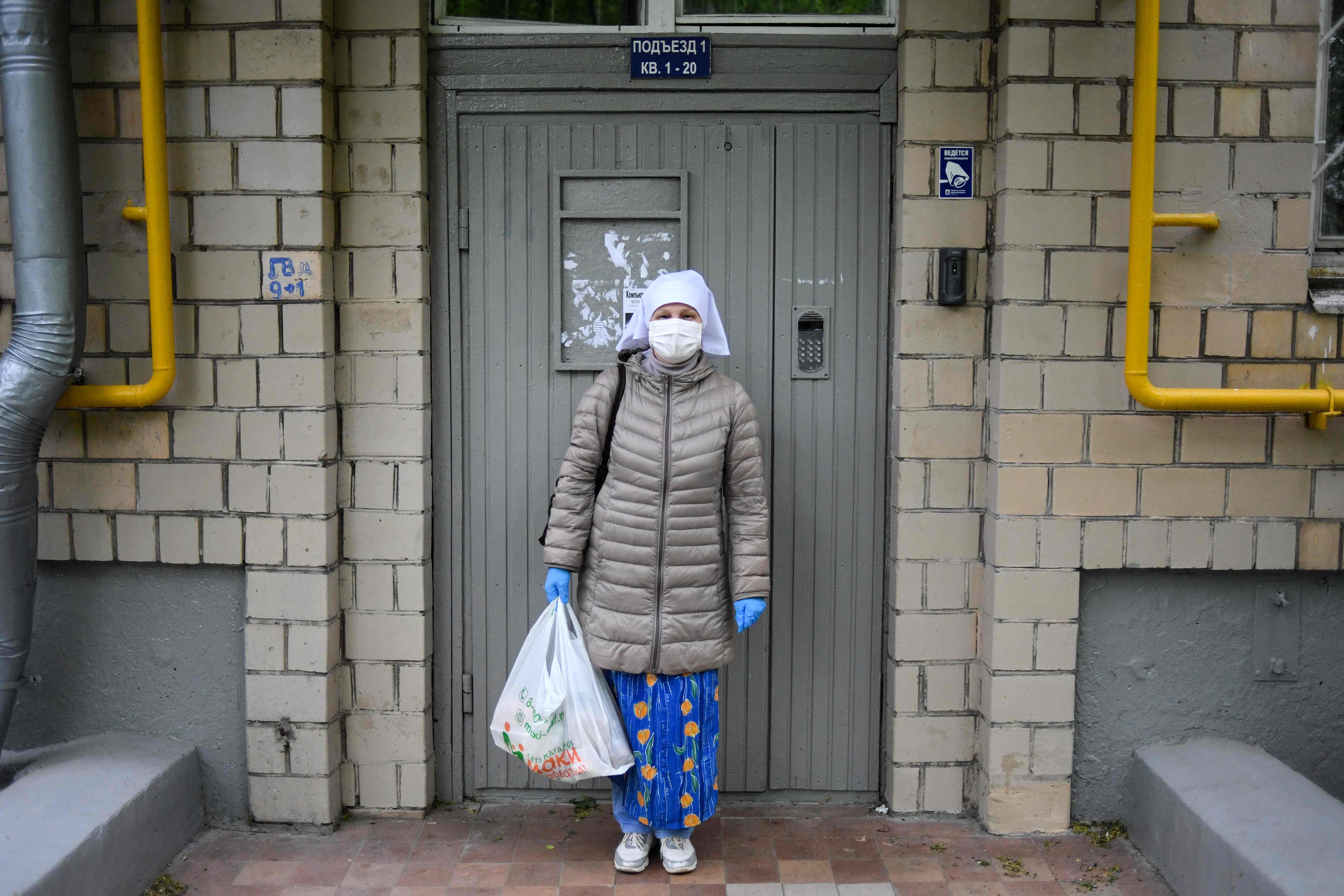 Warga Moskow eluar ruymah dengan menggunakan masker dan sarung tangan