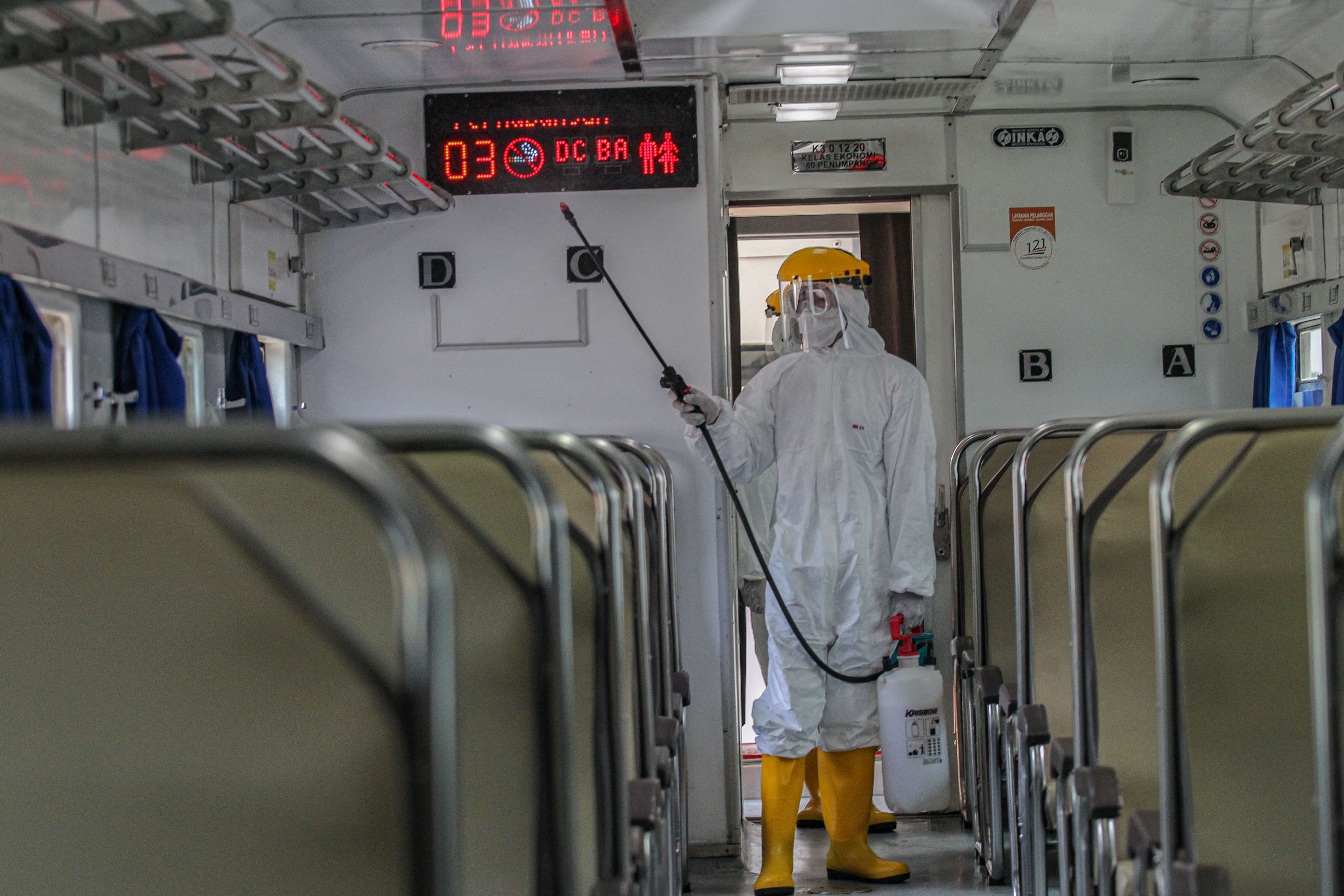 Petugas menyemprotkan cairan disinfektan di gerbong KA jarak jauh di Stasiun Pasar Senen Jakarta Pusat.