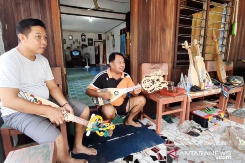 Harmuda (kanan) saat melayani salah seorang pembeli.