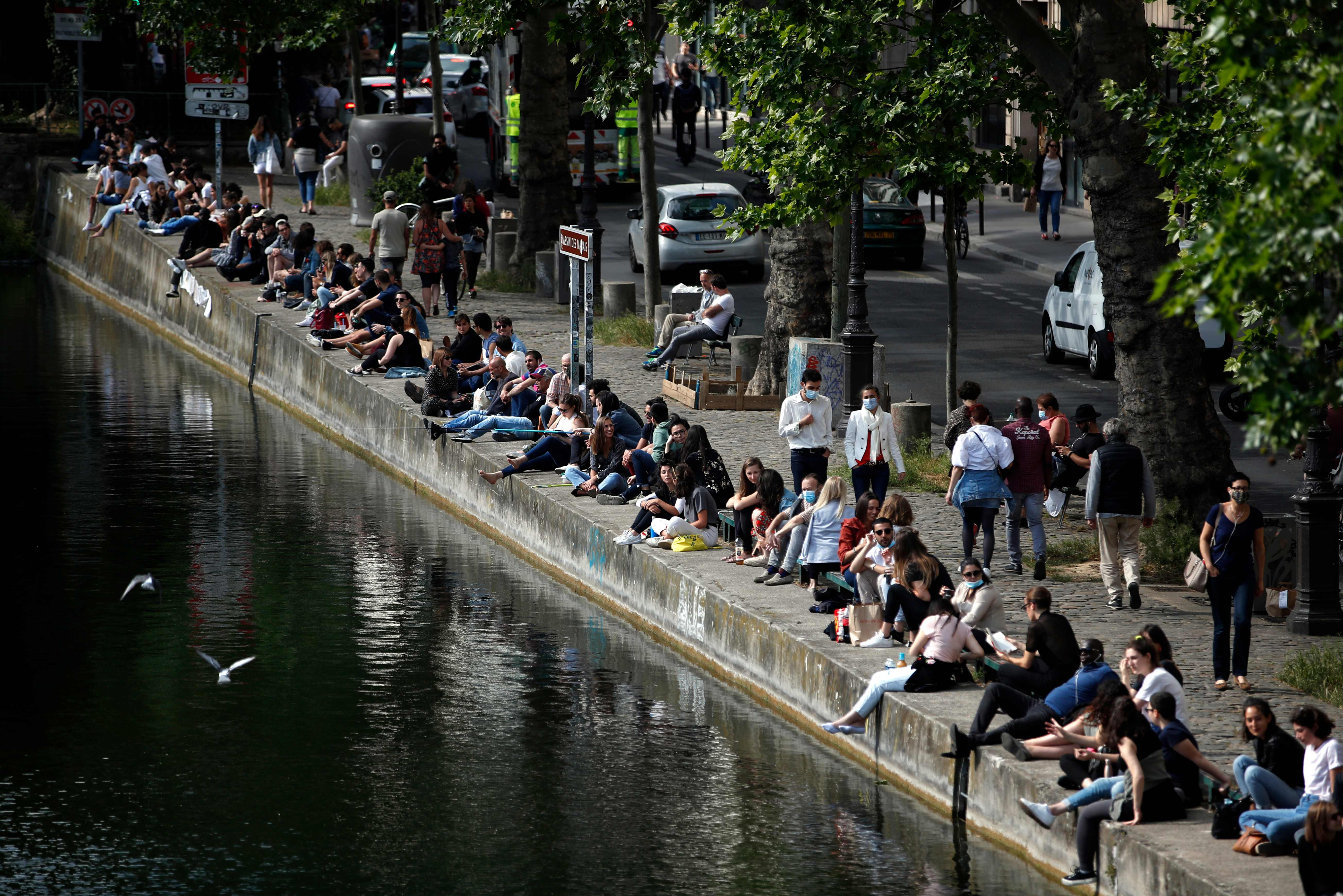 Warga duduk di tepi Canal Saint-Martin, Paris, Prancis, seiring dilonggarkannya aturan lockdown di negara itu.