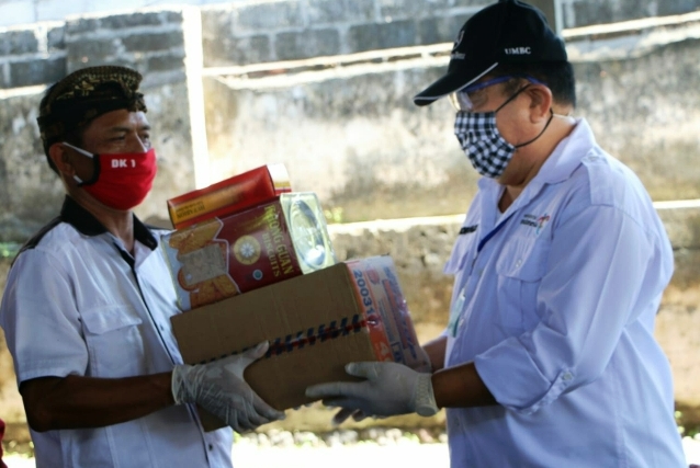 Wagub Bali, Tjokorda Oka Artha Ardhana Sukawati (kanan) menyerahkan sembako secara simbolis kepada warga Desa Padangkerta, Karangasem.