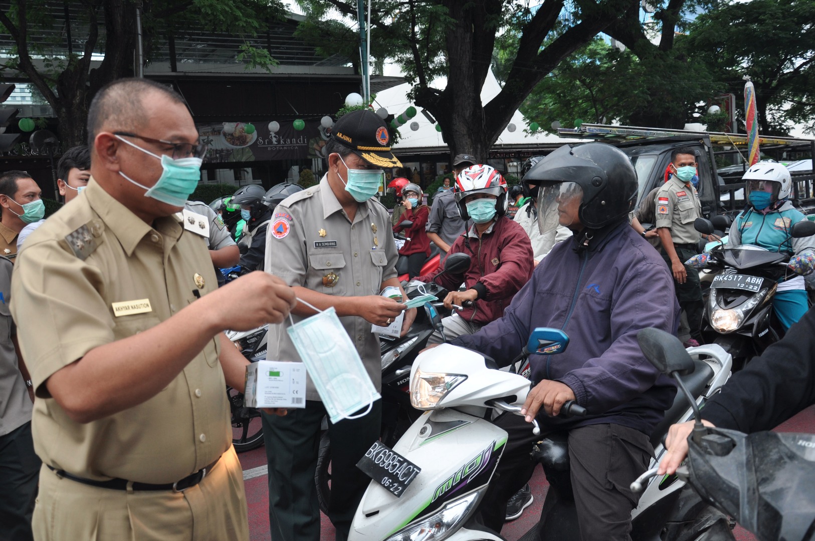 Plt Wali Kota Medan Akhyar Nasution (kiri) membagikan masker di kawasan Jalan Balaikota Medan, Sumatera Utara, Senin (23/3). 
