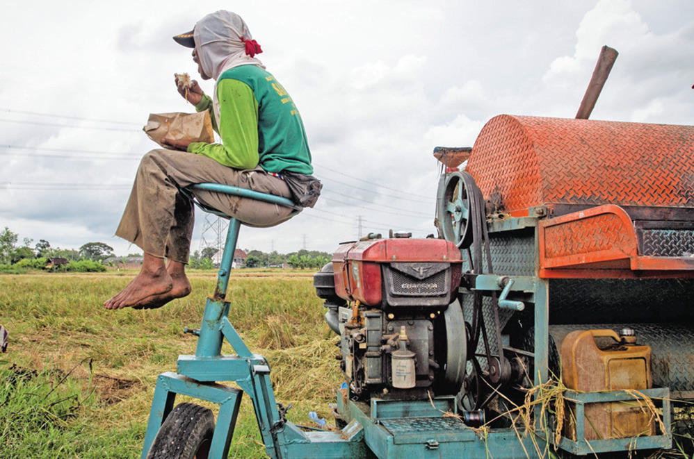 Buruh tani beristirahat sambil makan saat panen padi di Nguter, Sukoharjo, Jawa Tengah, kemarin.