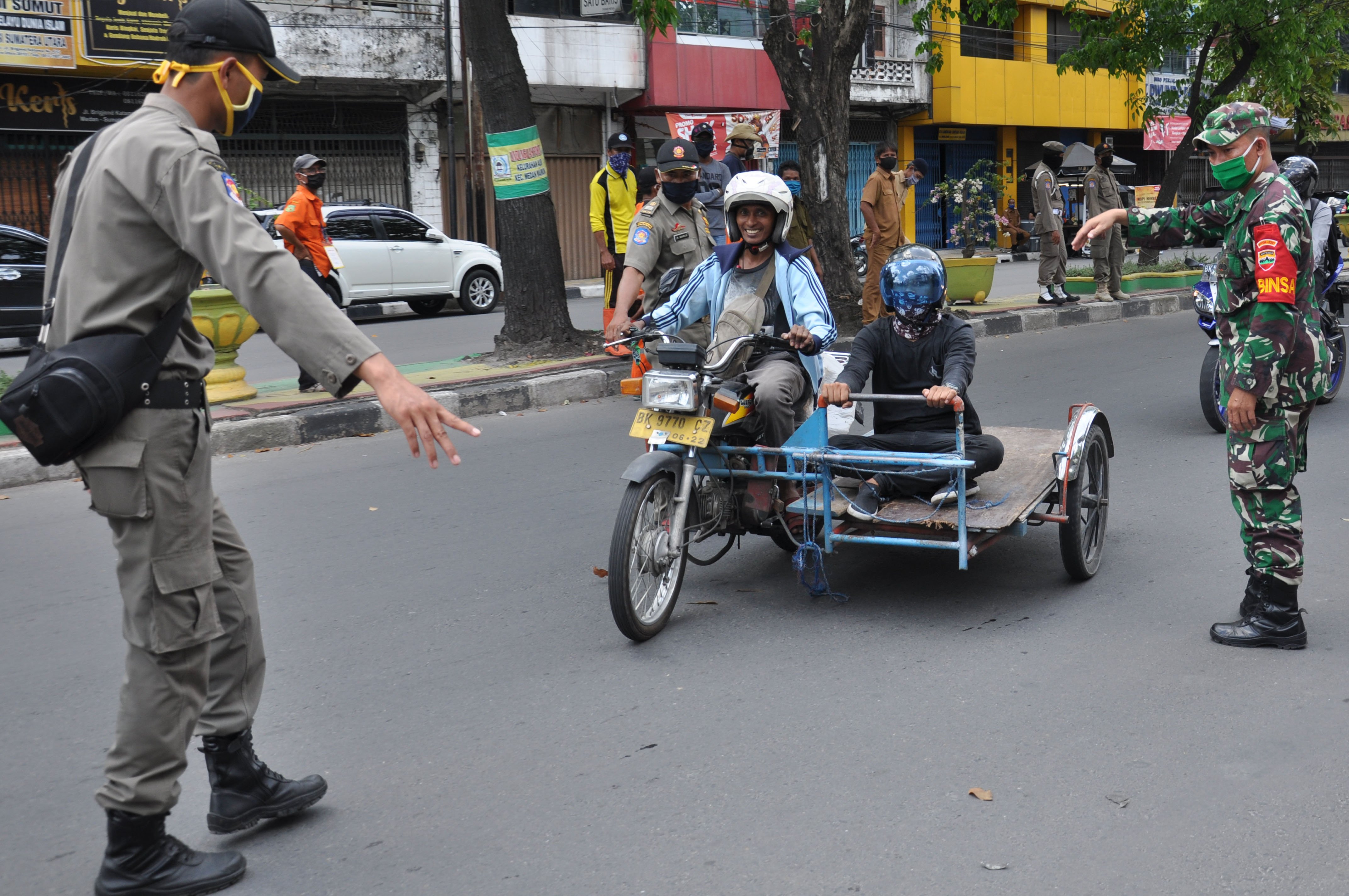 Petugas menghentikan warga yang tidak menggunakan masker di Medan, Sumatra Utara, Selasa (5/5).