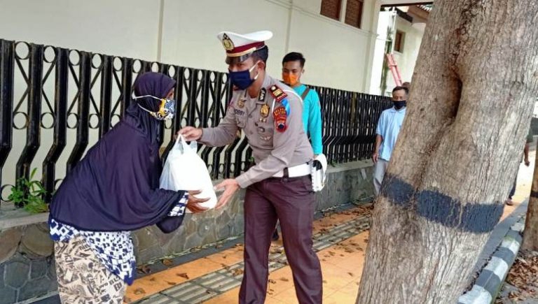 Petugas menyerahkan bantuan sembako kepada warga miskin di jalan  protokol Kota Klaten. 