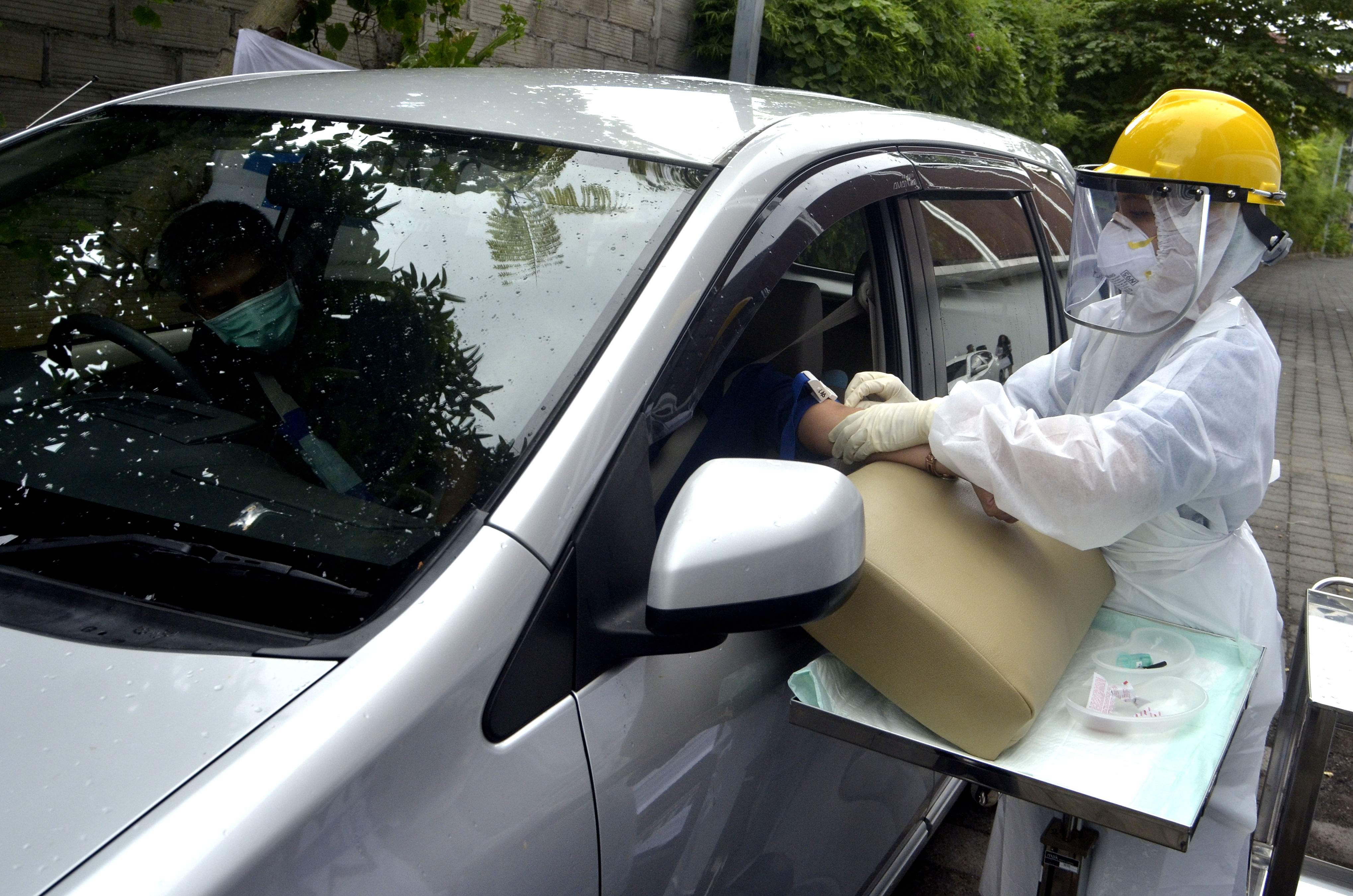  Petugas medis Rumah Sakit BIMC Siloam, Nusa Dua, mengambil sampel darah pengguna kendaraan saat tes cepat atau 'rapid test' COVID-19.
