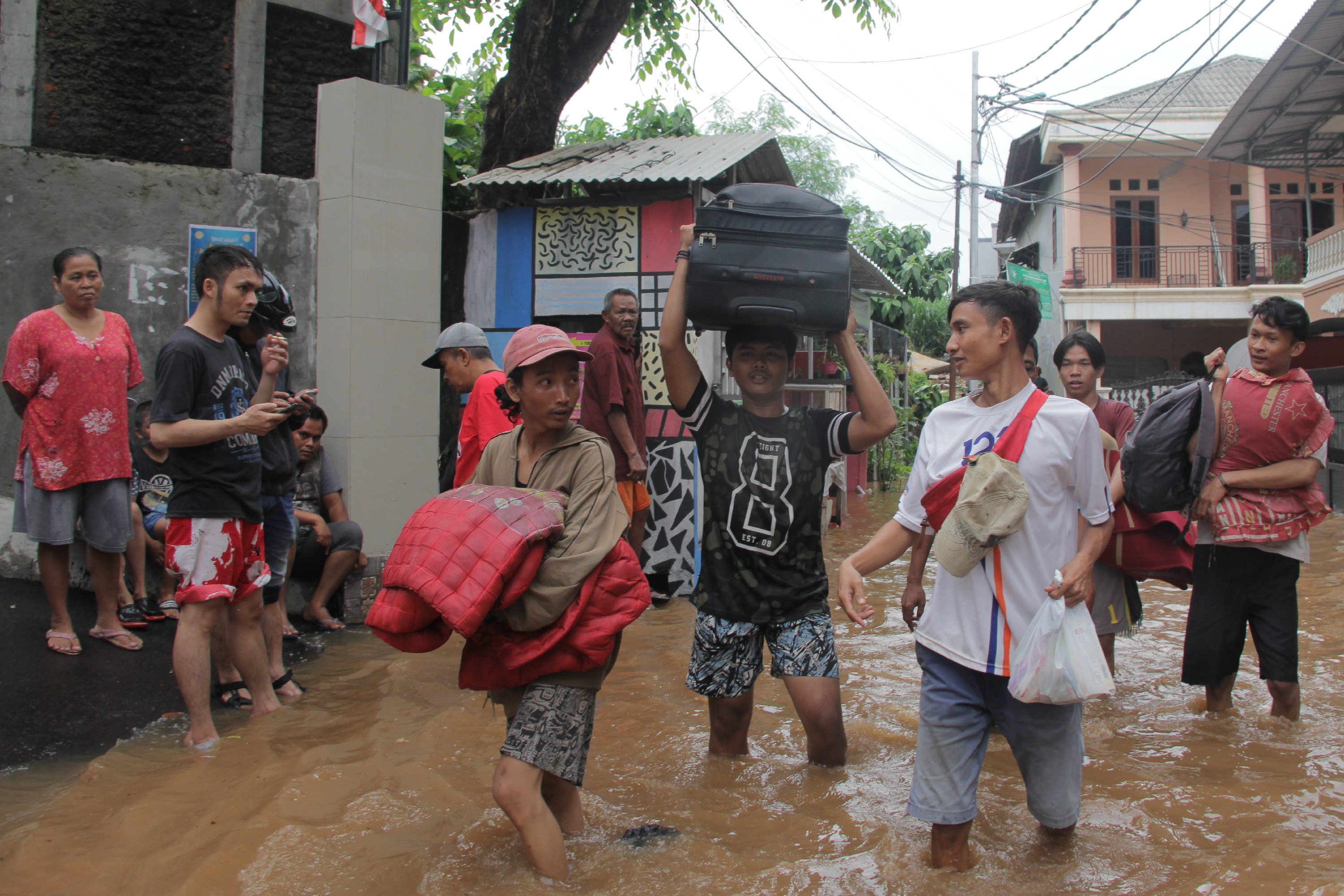  Warga menyelamatkan barang berharga di rumah yang terendam banjir di kawasan Cililitan, Kramat Jati, Jakarta Timur, awal tahun 2020