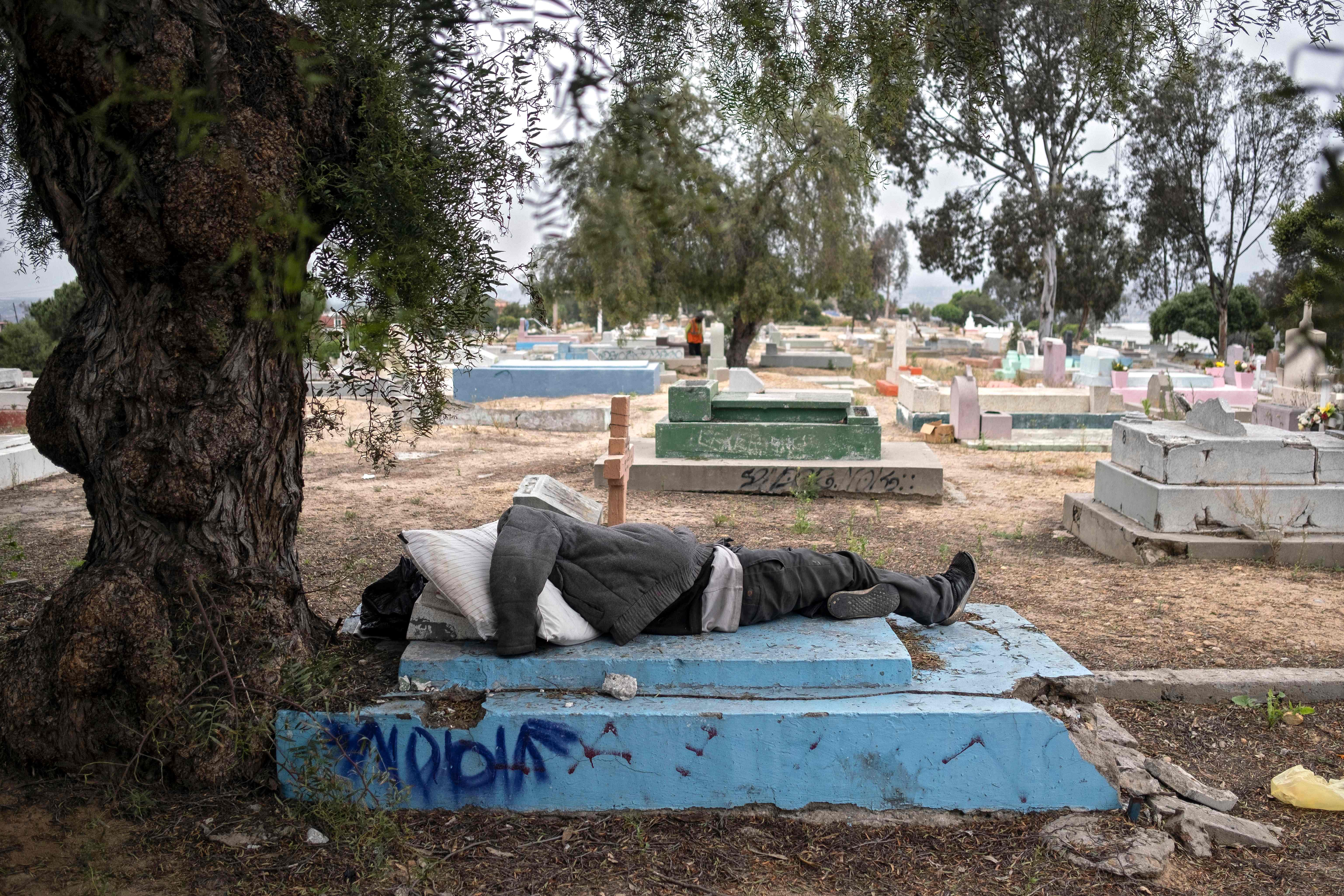 Seorang tuna wisma tidur di sebuah pemakaman di Tijuana, Baja California State, Mexico, Minggu (10/5).