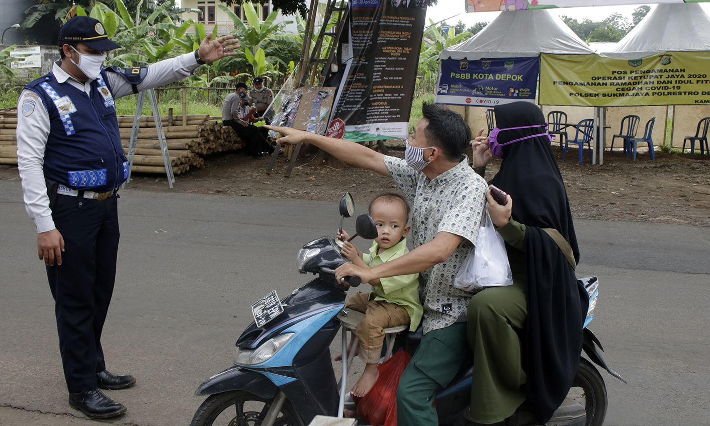 Petugas menyetop pengendara saat pelaksanaan PSBB di check point jalur alternatif Kampung Sawah, Cilodong, Depok, Jawa Barat.